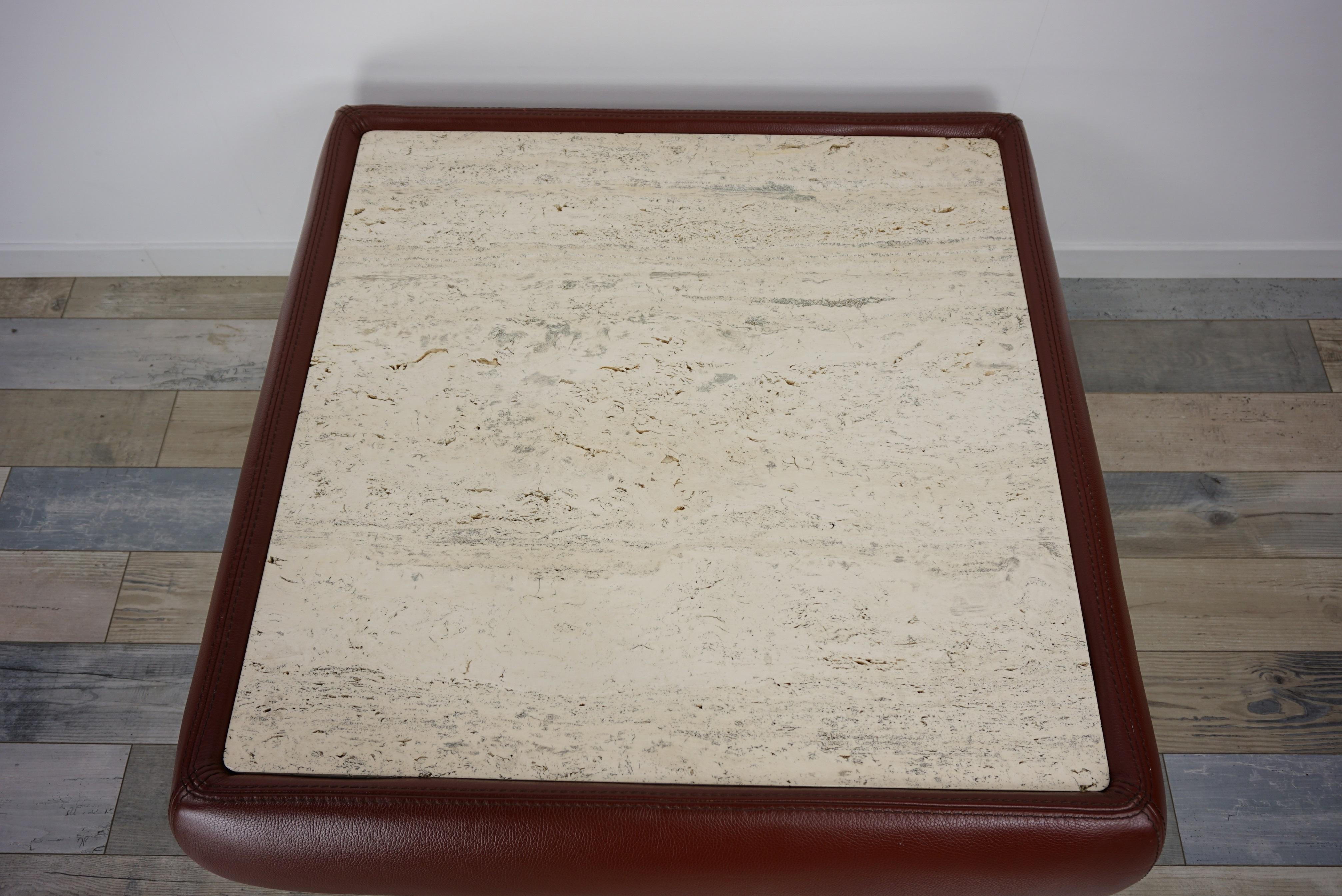 Coffee table design 1970s-1980s, with graphical and geometric lines, structure furnished with chocolate-colored leather adorned with a square travertine tray (73cm/73cm). All in very beautiful state of conservation.