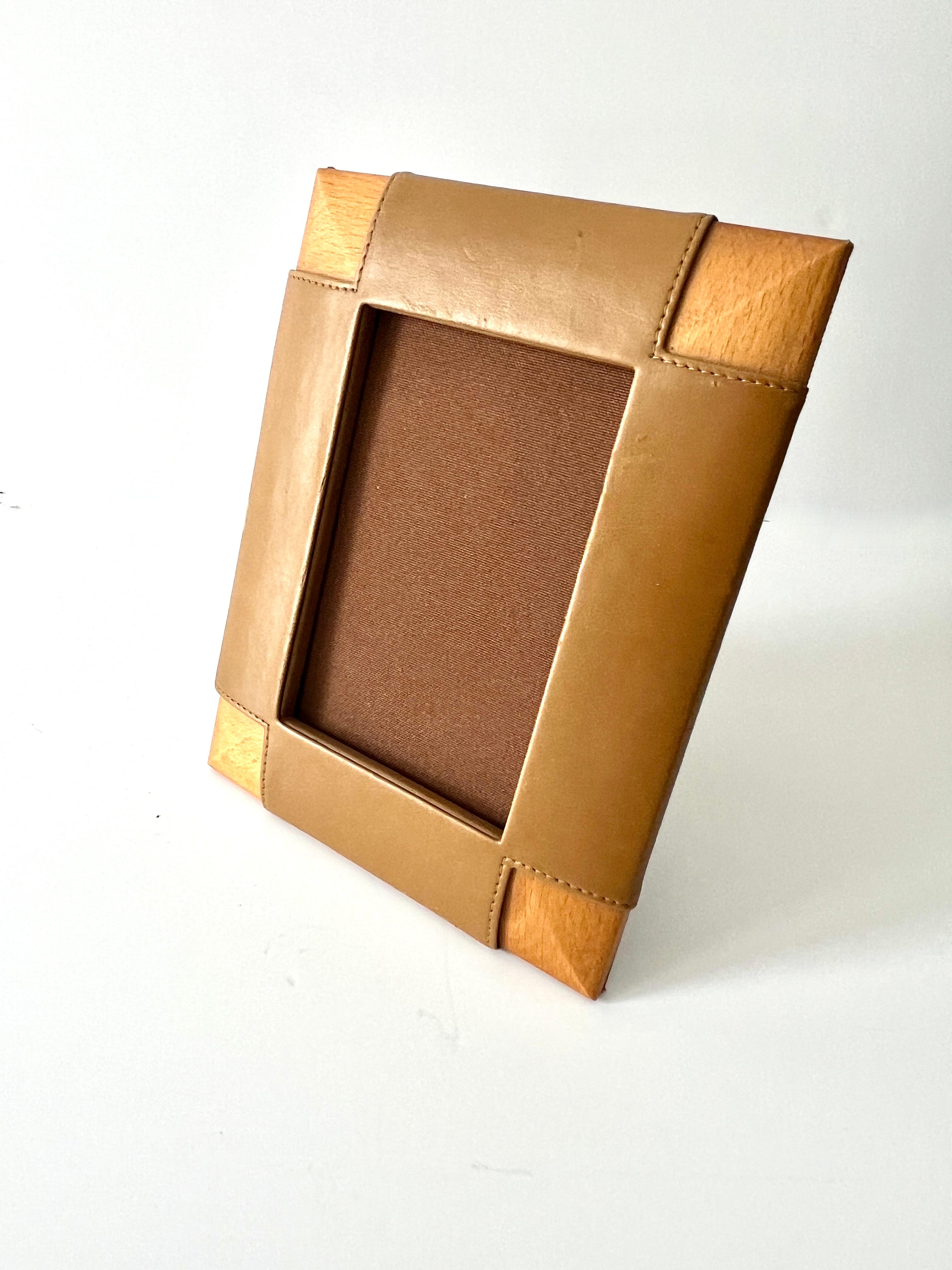 A wonderful picture frame in the style of Ralph Lauren.

The frame is fabricated with mitered Wood and Leather on each side, leaving the corners exposed.  A unique color in Butterscotch  or Caramel. 

A compliment to any photo collection, resting on