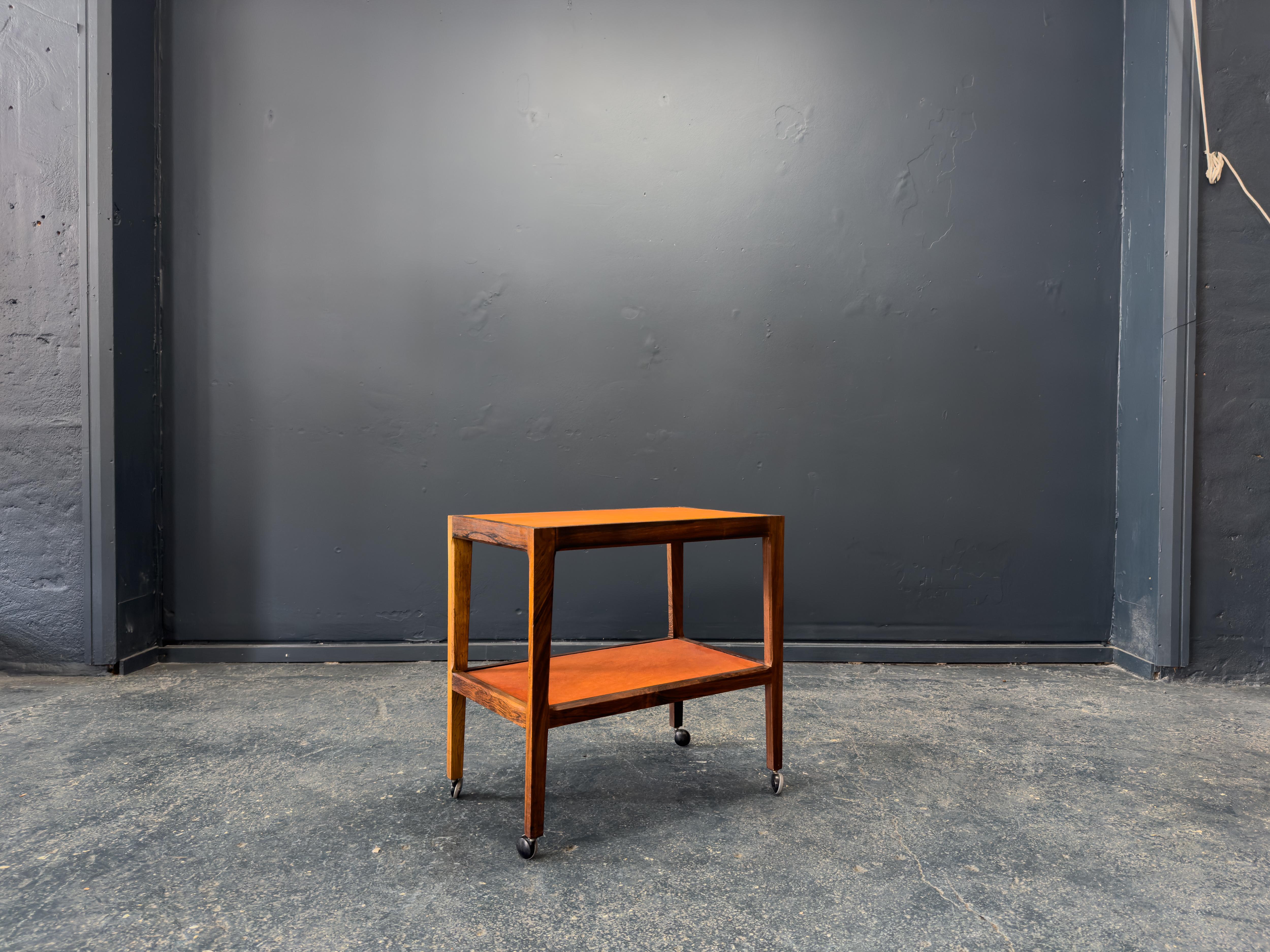 This leather and wood unit on wheels is a refined and versatile piece that perfectly captures the elegance of Scandinavian design. Crafted from richly grained wood, the frame showcases clean lines and a minimalist silhouette, elevated by the
