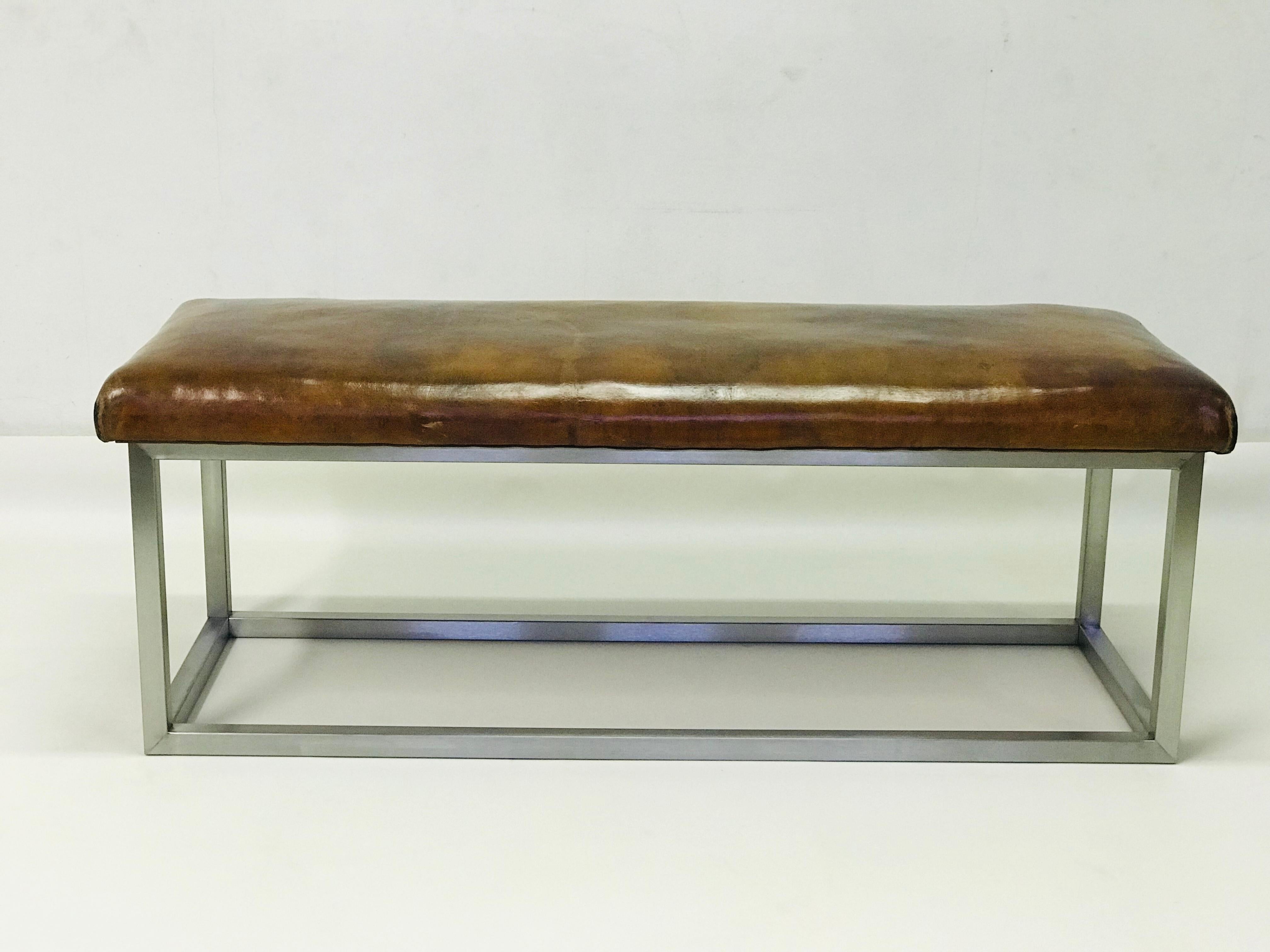 The bench has strong leather completed the stainless steel construction. The leather is in the original patina.