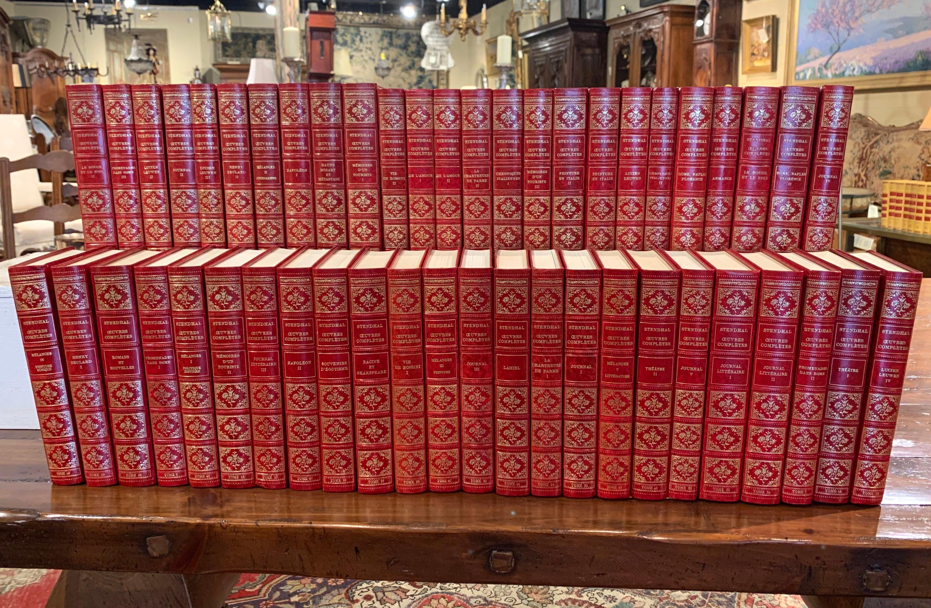Decorate a study or a library with this elegant set of French books; printed in Switzerland circa 1972, each book has a red leather bound cover with gilt embossed motifs. The set of 49 books, titled 