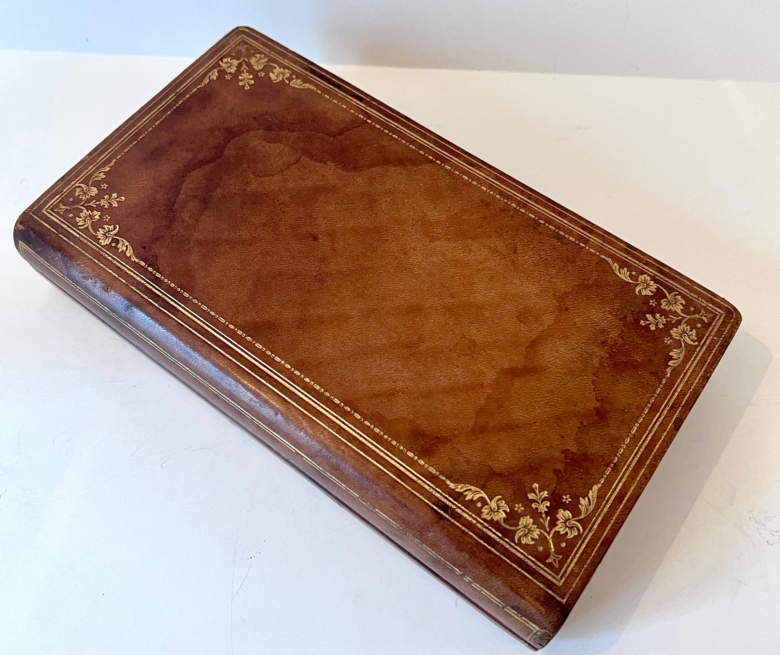 The look of a leather bound book with fine gold tooling to the exterior. Originally used for Bridge scorecard and playing cards (included). The piece is a compliment to the bookshelf or side table, desk, or workspace. 

With the hinged ease of