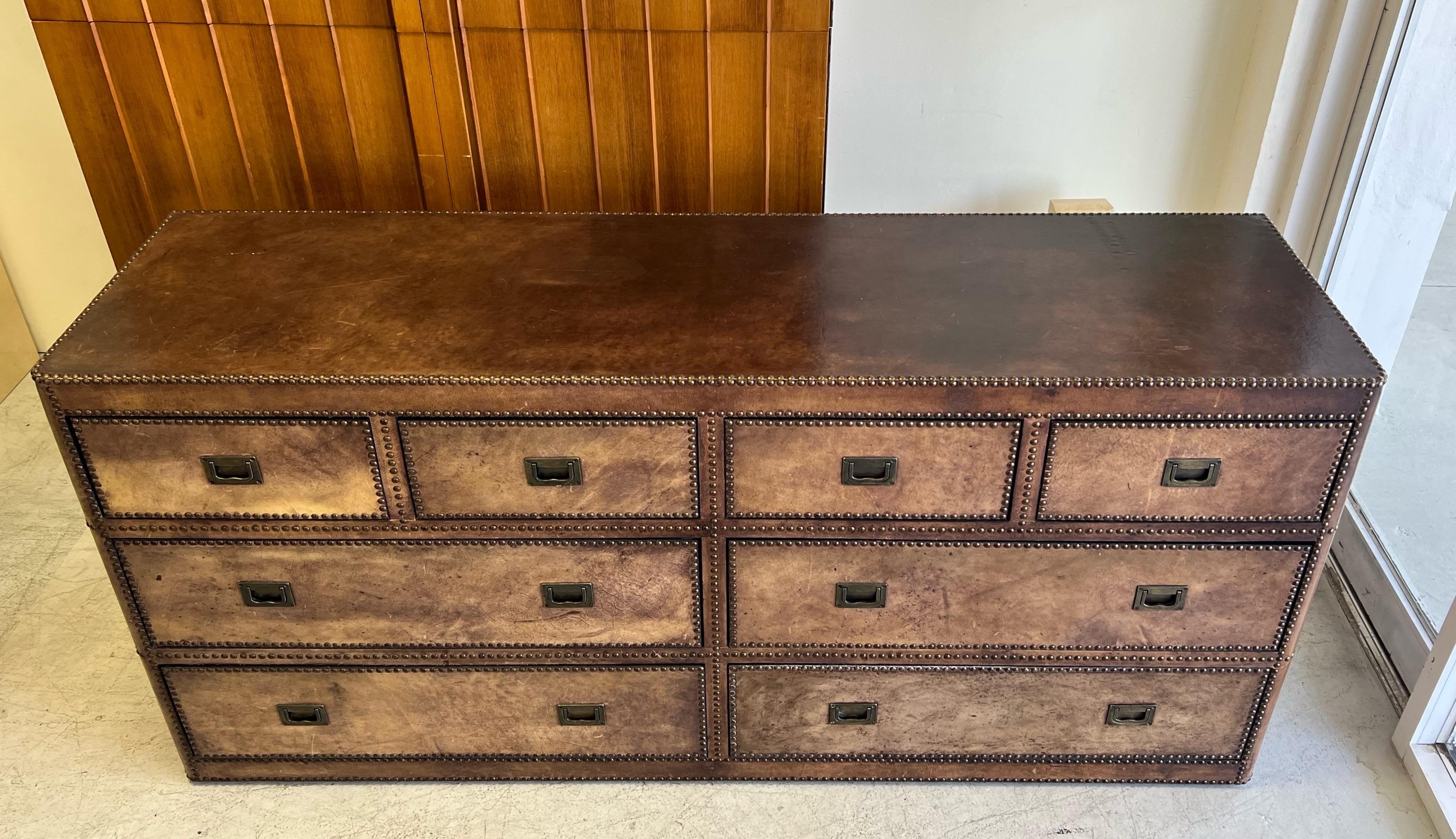 A leather clad cabinet with tacks on all edges. Even the back is done in leather. The cabinet is on casters. The interior of the drawers in done in black paint. Lots of storage.