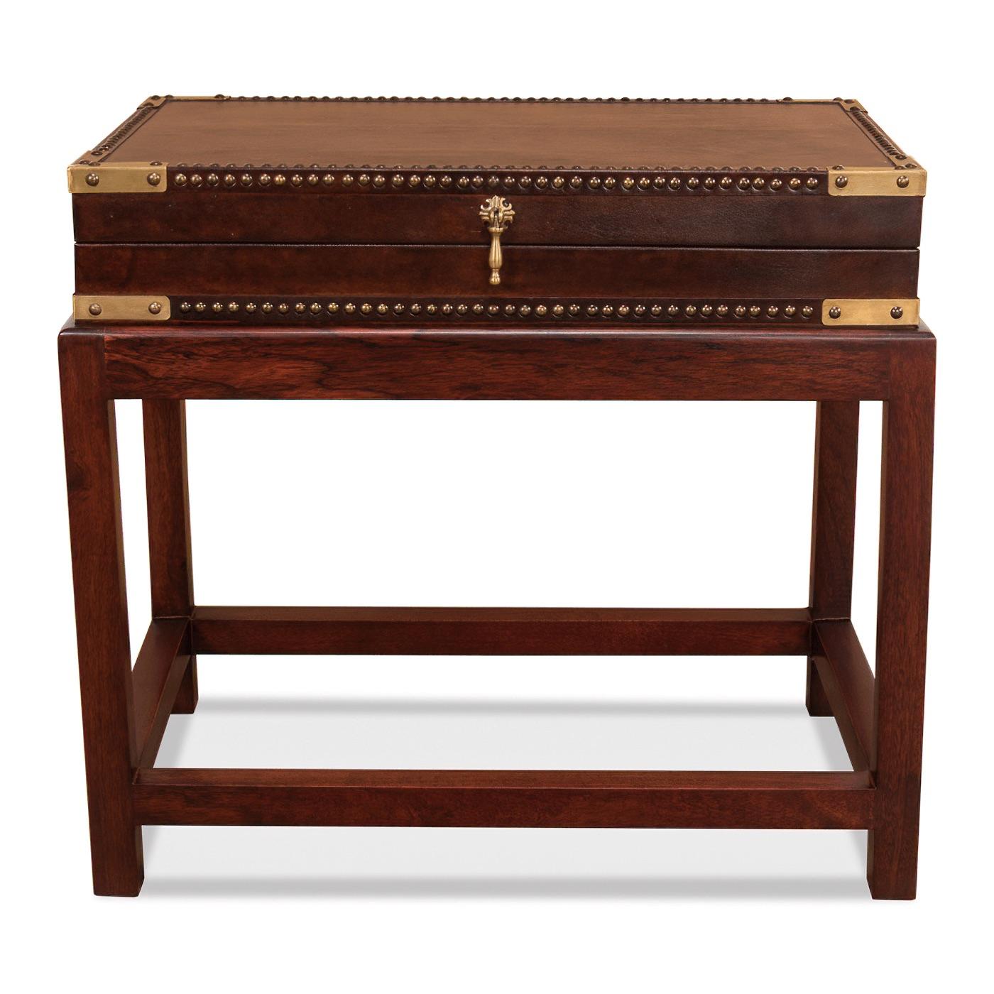 Recouvert d'un cuir antique marron, cette pièce présente une boîte rectangulaire rehaussée d'une garniture de tête de clou en laiton. L'intérieur révèle une touche de charme surprise avec une doublure en papier imprimé, rappelant le style et