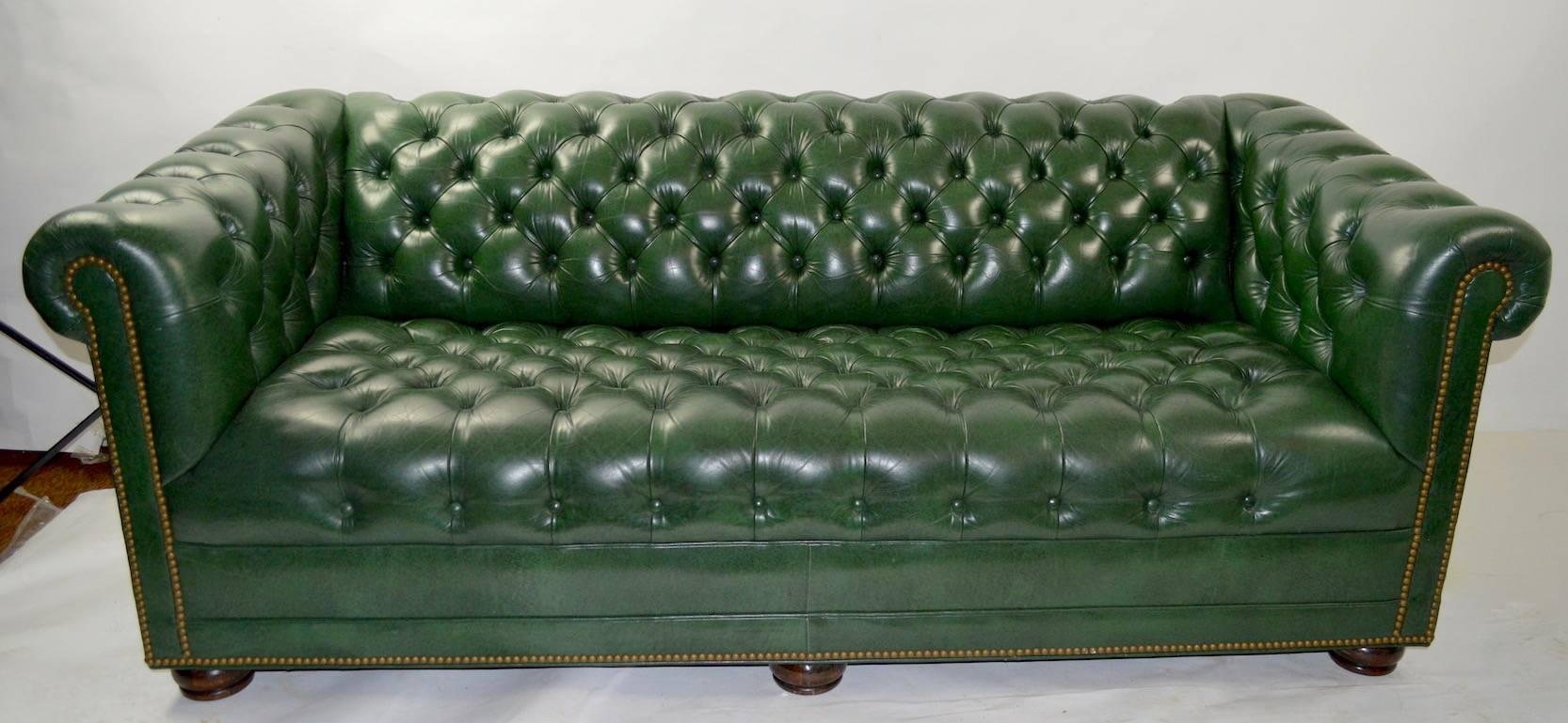 Chesterfield style box sofa with tufted leather upholstery on bun feet, by Hancock and Moore. The restrained Classical style works with traditional as well as modern interiors. This example is in excellent original condition, clean and ready to use.