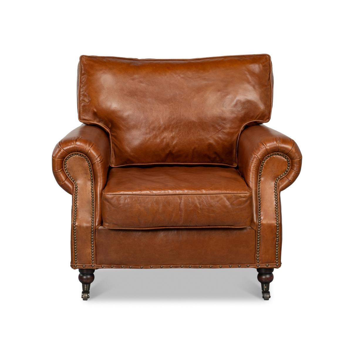 A leather upholstered club chair, in a vintage cigar brown aniline top-grade leather with a deep upholstered cushion backrest and seat cushion with rollover upholstered arms, finished with brass nailheads on mahogany feet with