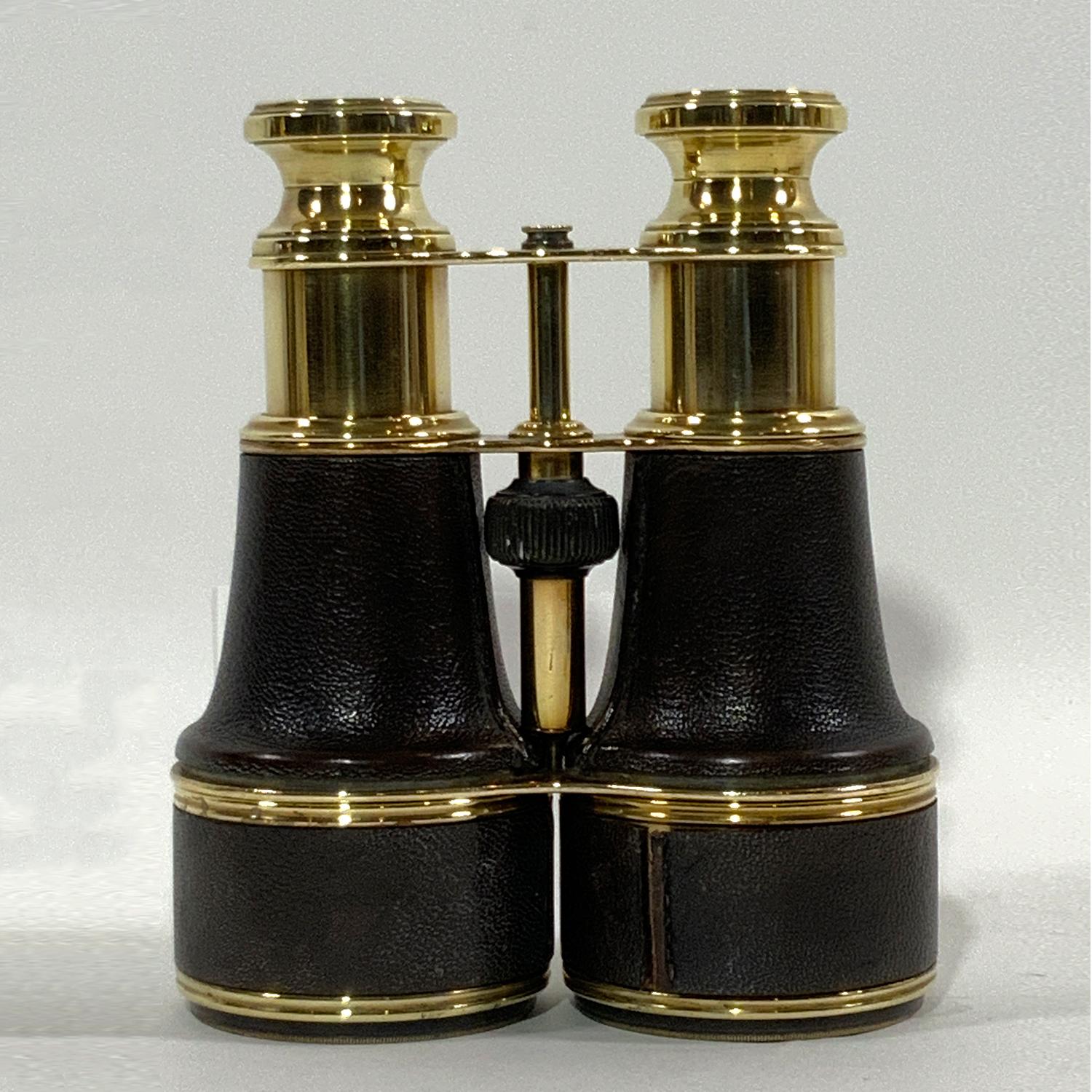 Early twentieth century yachting binoculars with fine brown leather covers on the barrels and sunshades. Knurled focal knob operates well. Clear view. Circa 1925.