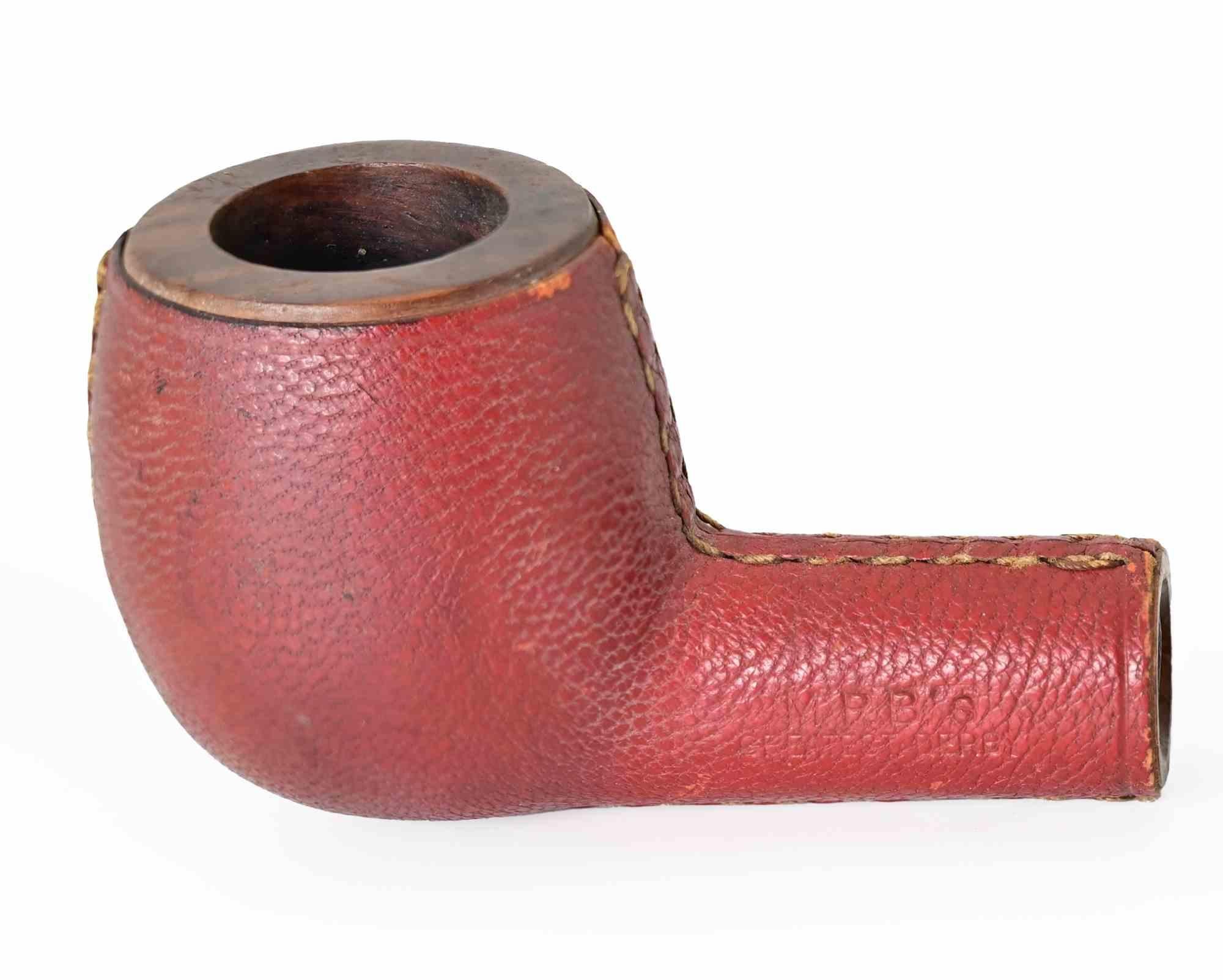 Une pipe à fumer remarquable et de collection, dotée d'un bol et d'une tige en bois de bruyère entièrement revêtus de cuir rouge texturé, finement cousu à la main le long de la tige et sur le contour du bol. Ce traitement inhabituel protège la