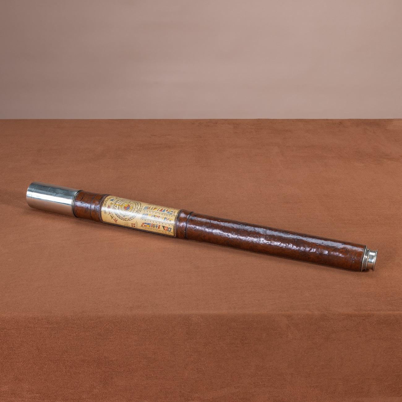 An unusual English nineteenth century leather and nickel plated brass single drawer hand held Naval telescope that has sliding eyepiece lens cover, extending shade and a panel inset into the leather showing signal flags/pendents for identification