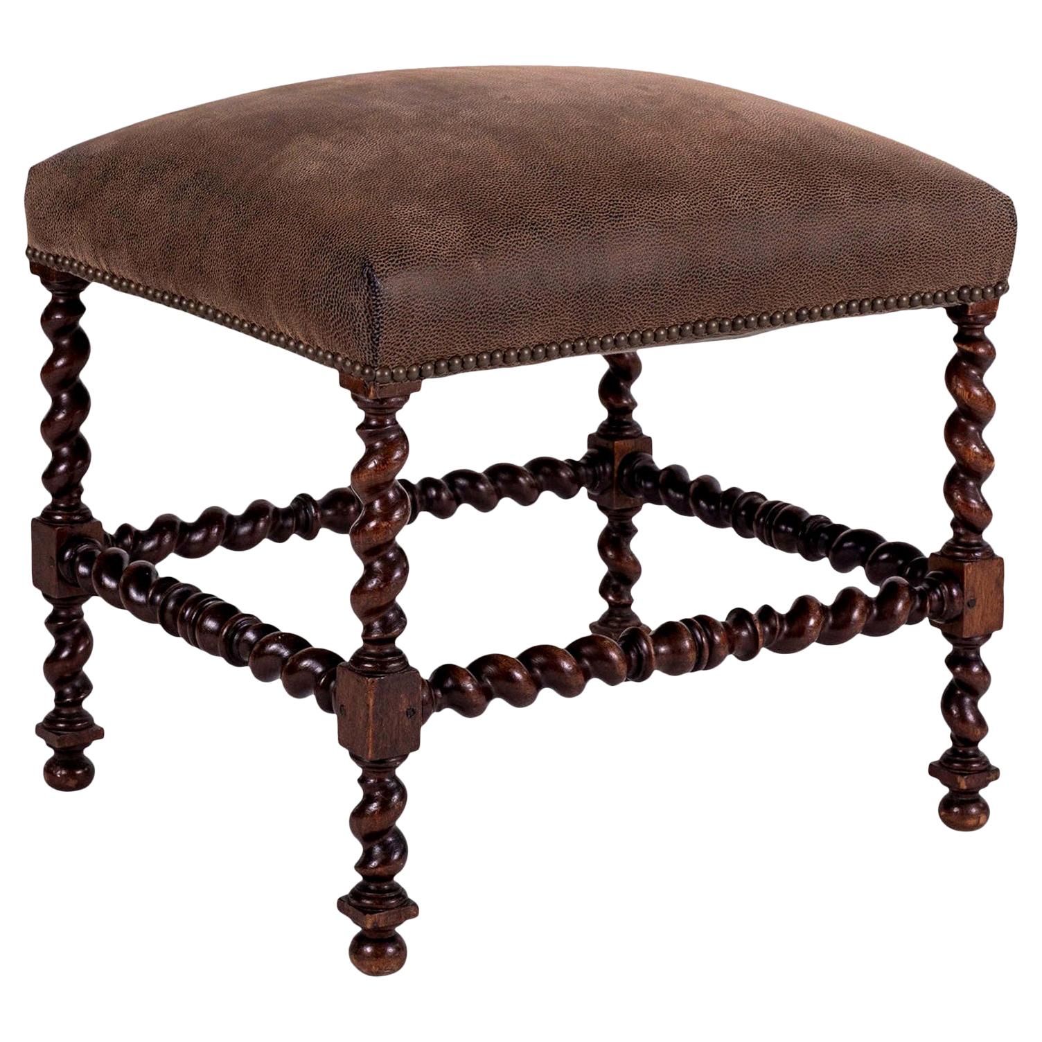 Leather-covered Louis XIII walnut stool dating to the 19th century. French stool hand carved in walnut. Barley-twist style legs and stretchers. Featuring mortise and tenon construction (evidence of joints tightened in the past). Covered in fine