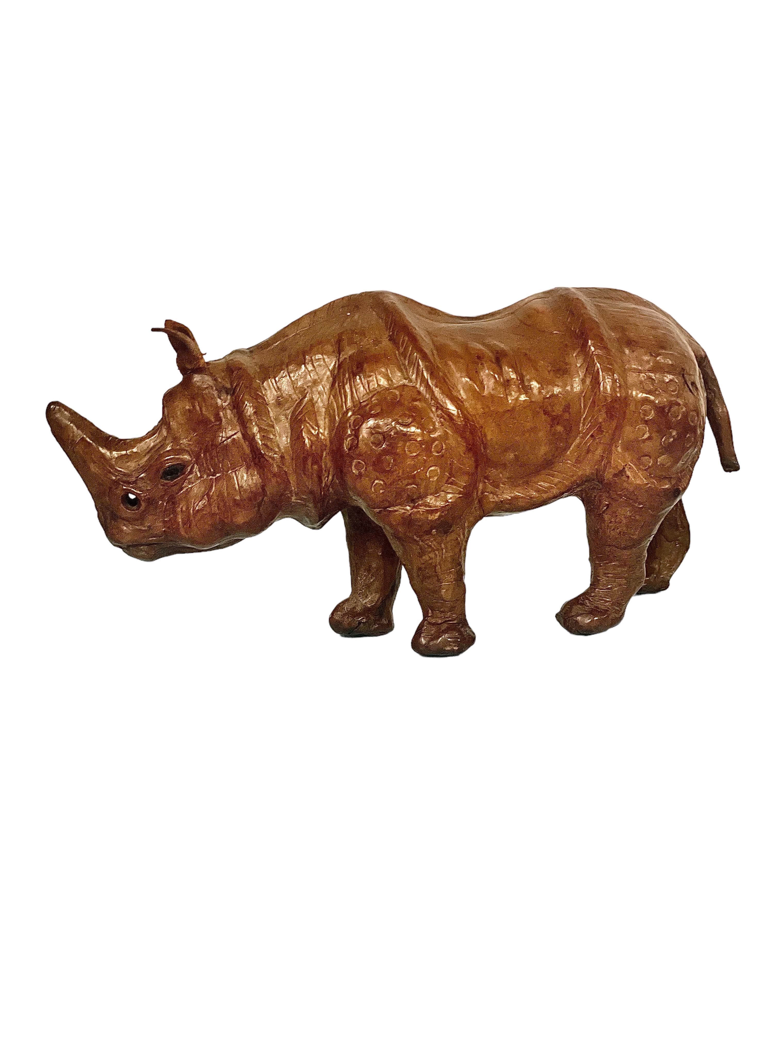 Un magnifique ornement vintage en forme de rhinocéros, sculpté à la main et recouvert de cuir, avec des yeux en verre noir. Datant des années 1950 environ, cette majestueuse petite sculpture est pleine de détails réalistes et artistiques et d'un
