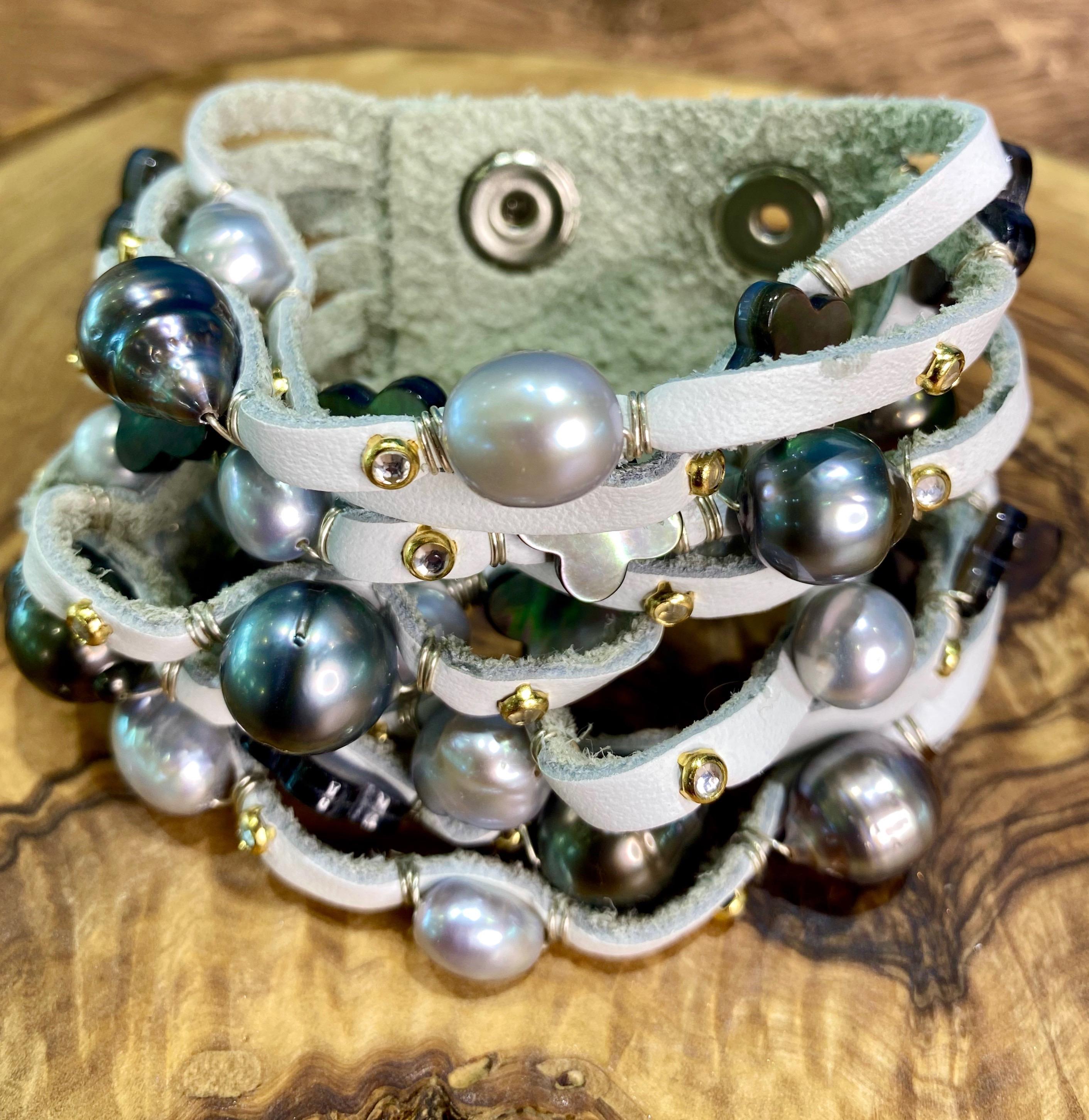 Bijoux De Mer's signature cuff has got the WOW factor with this combination of 10mm Tahitian pearls and silvery freshwater pearls mixed with mother of pearl clovers.  The pearls and stones are hand-wired onto soft, calf skin leather with sterling