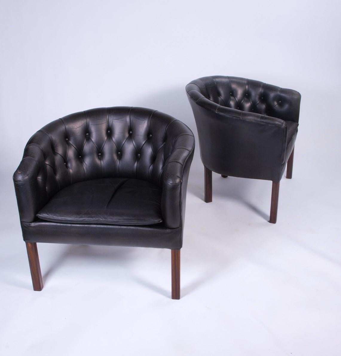 These Danish-made tufted lounge chairs exude timeless elegance. Adorned in rich black patinated leather, they possess a classic allure and retain their charm despite being in a gently used condition. 

While the designer and manufacturer remain