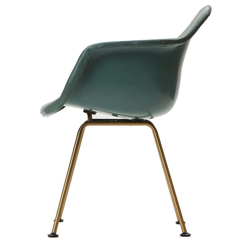A 'DAX' rope edge fiberglass zenith shell chair designed by Charles & Ray Eames with brass-finished legs retaining the original turquoise green leather upholstery over a matching fiberglass shell. Made by Herman Miller in the USA, circa 1960s.
 