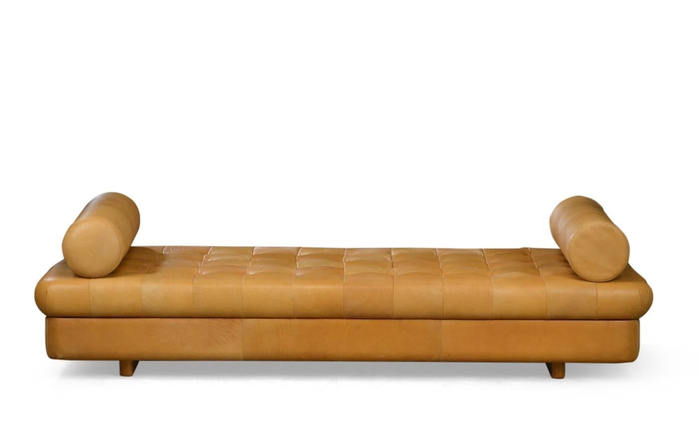 Padded daybed in patinated brown leather, buttoned, on wooden feet. Size of the bedding. H. 33, L. 200, B. 87 cm. Seating has some cracks.