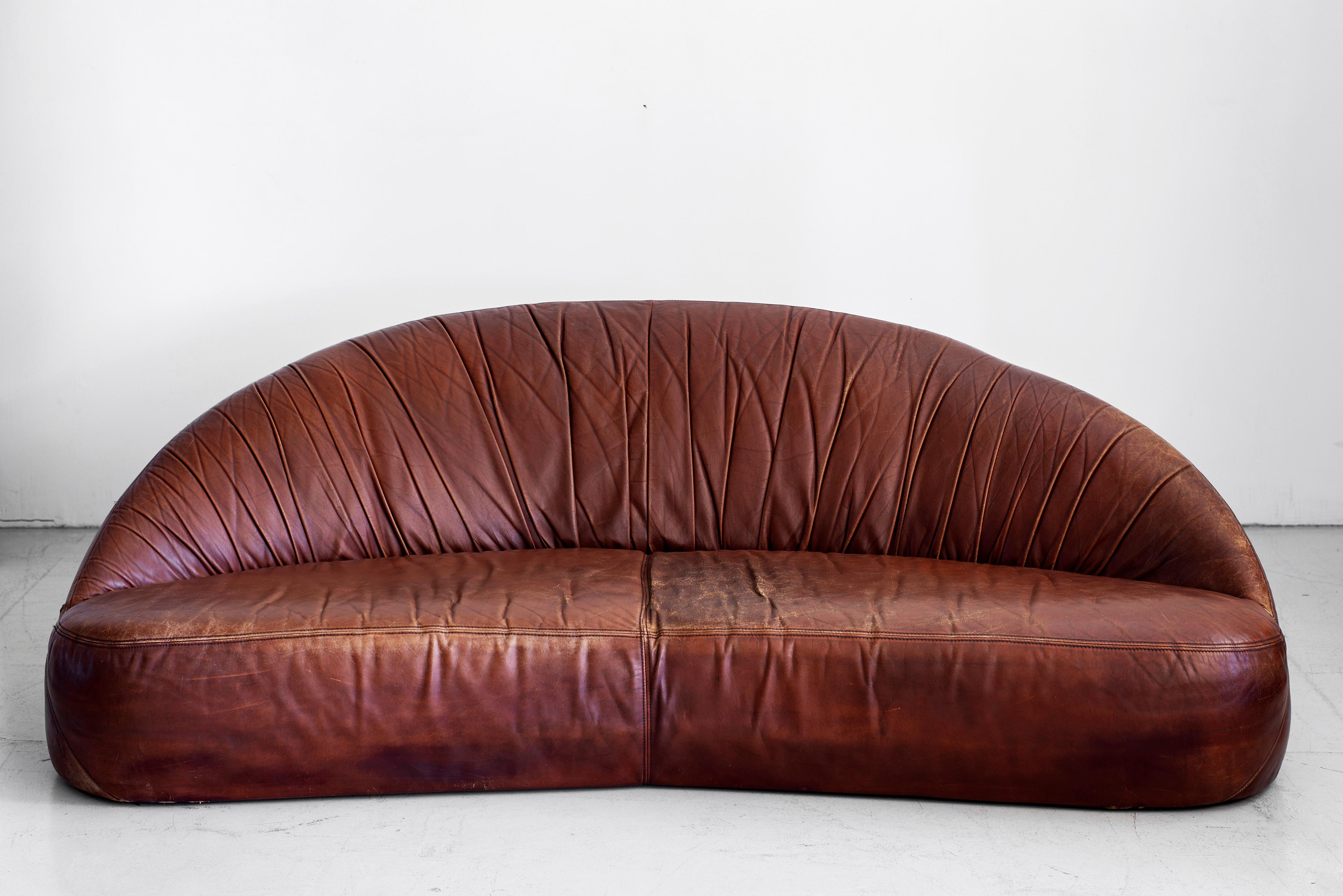 Great demilune sofa in rich brown original leather, France, circa 1970s. Nice patina and age to leather. Matching smaller sofa also available.