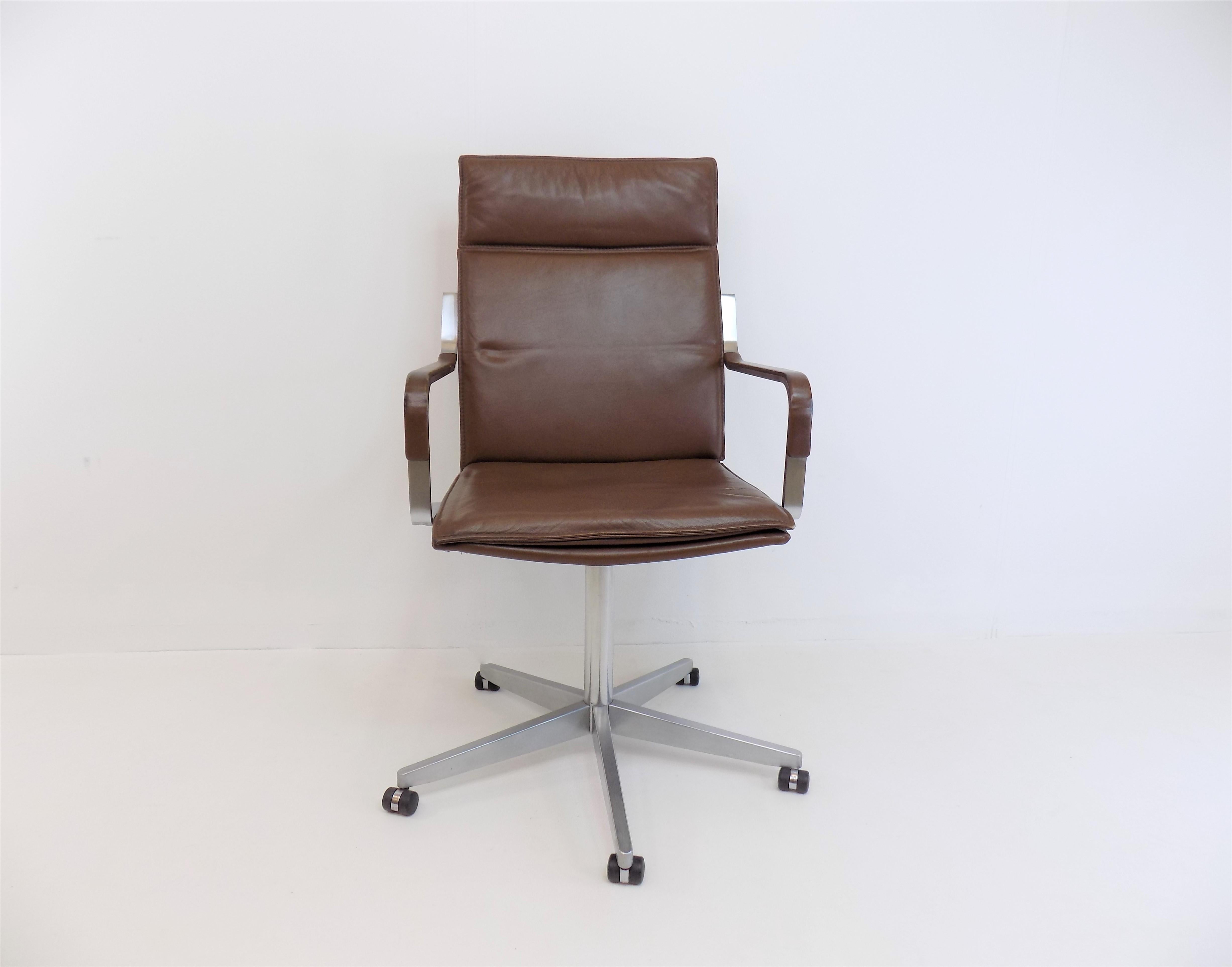 The Knoll office chair in cognac-colored leather is in good condition. The leather of the backrest and the seat and back cushions shows minimal signs of wear on the corners. The leather pads on the armrests show pressure points in the front area of