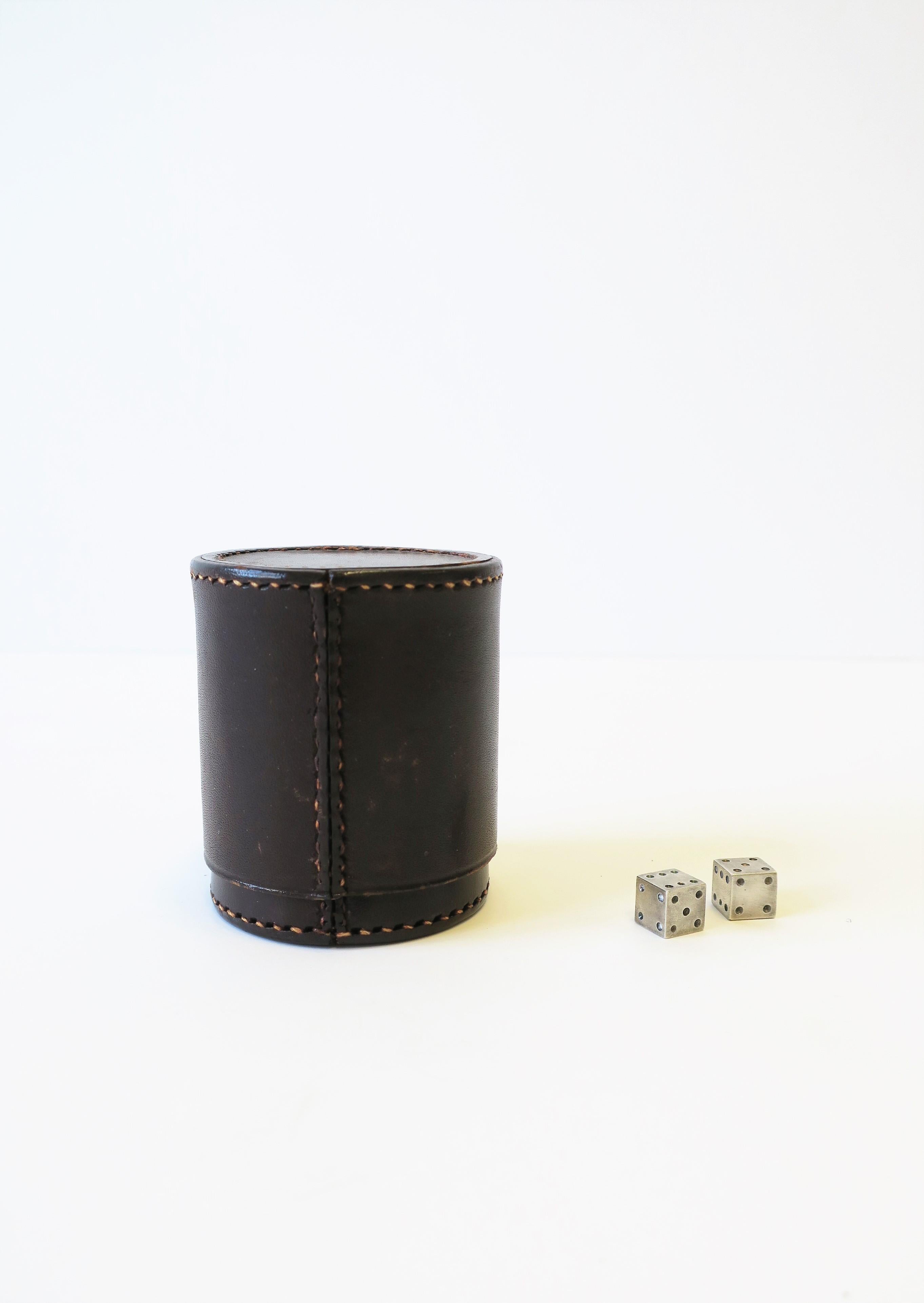 A rich dark brown leather dice shaker with stitch detail and a set of heavy small steel dice, circa mid to late-20th century. A great set for games (board, card games, etc.) Dimensions: 2.69