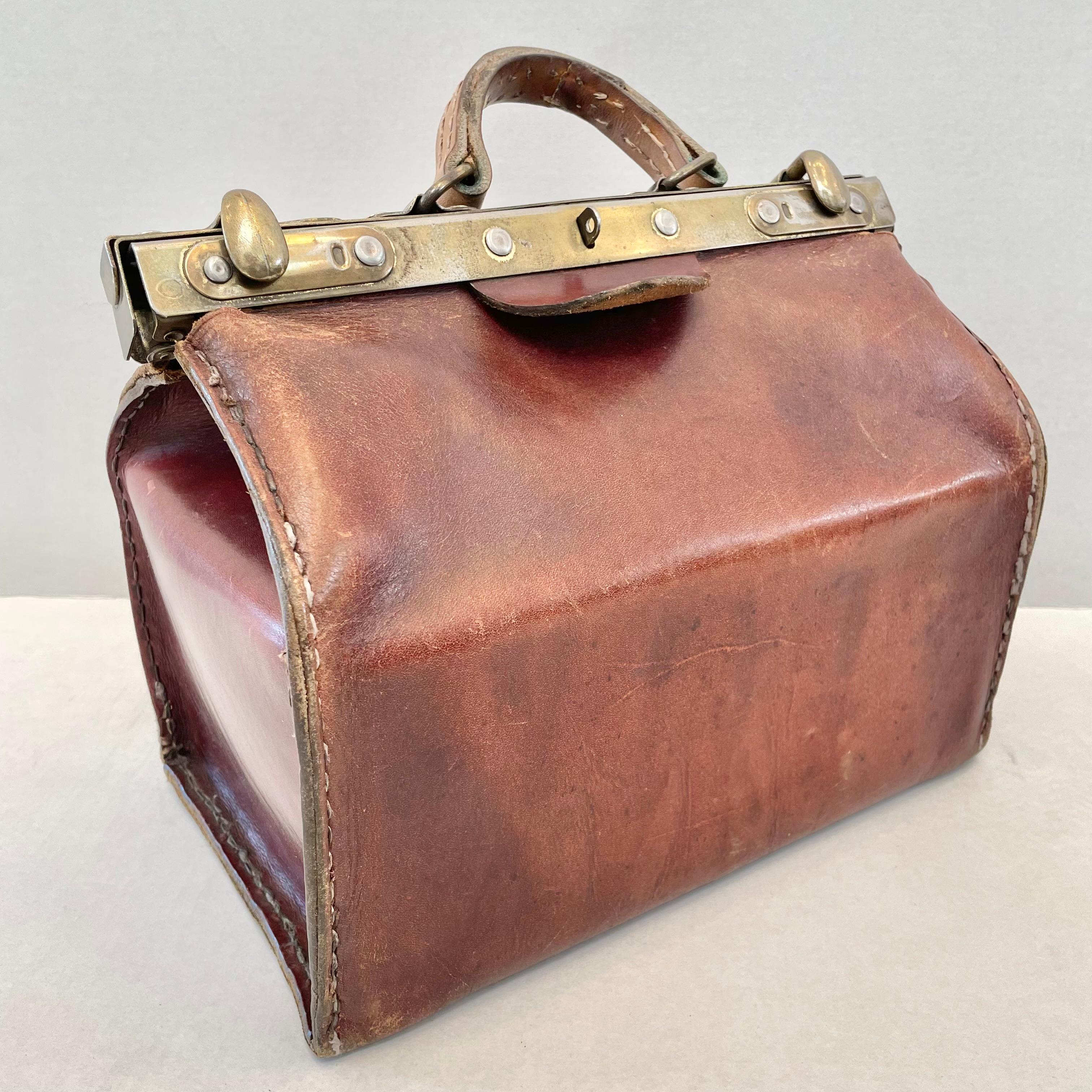 Substantial cowhide bag with brass hardware and closure. Used a travel bag for physicians to play tools and prescriptions in. Perfect as a purse or for travel. This structured bag is made with extremely thick saddle leather and brass hardware with a