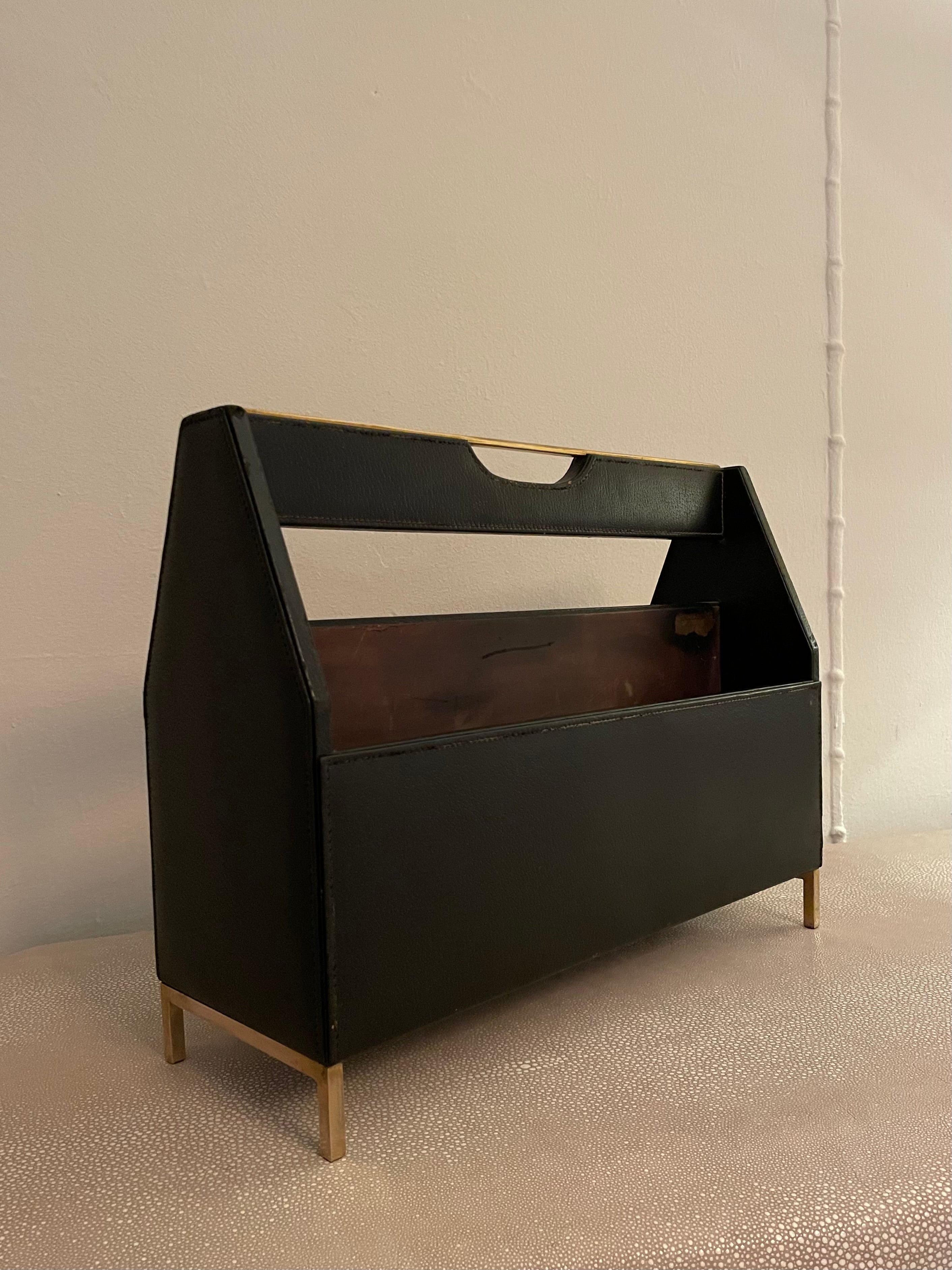 A lovely magazine rack of leather by the Cross Pen Co. - the piece has brass accents on top and with the legs. The top brass piece acts as a handle and on either side are compartments for periodicals, books or documents.

While there were some