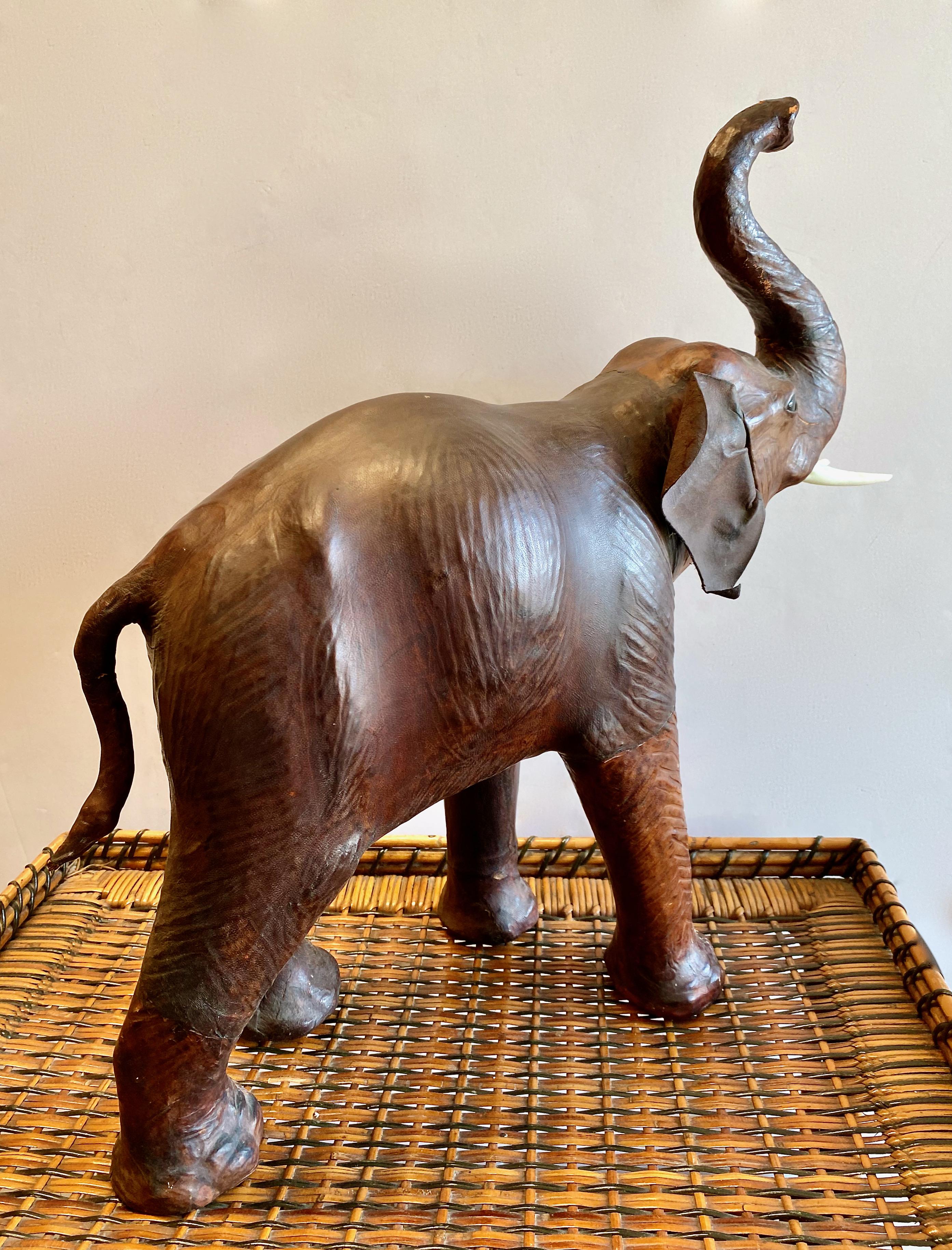 This is the second and slightly smaller of two c. 1950s leather clad elephants. This charming guy is in very good original condition--he maintains his original faux ivory tusks and leather. All elements appear to be original and he is without major