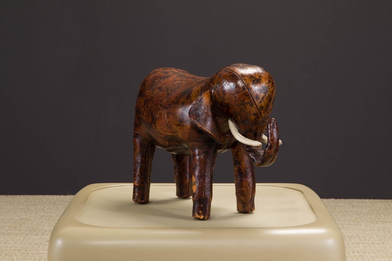 A wonderful collectors example of an original leather elephant footstool by Dimitri Omersa for Abercrombie and Fitch, circa 1963. This example is signed with the circle 'A&F CO' embossed stamp under one ear, has the early nail heads under its feet,