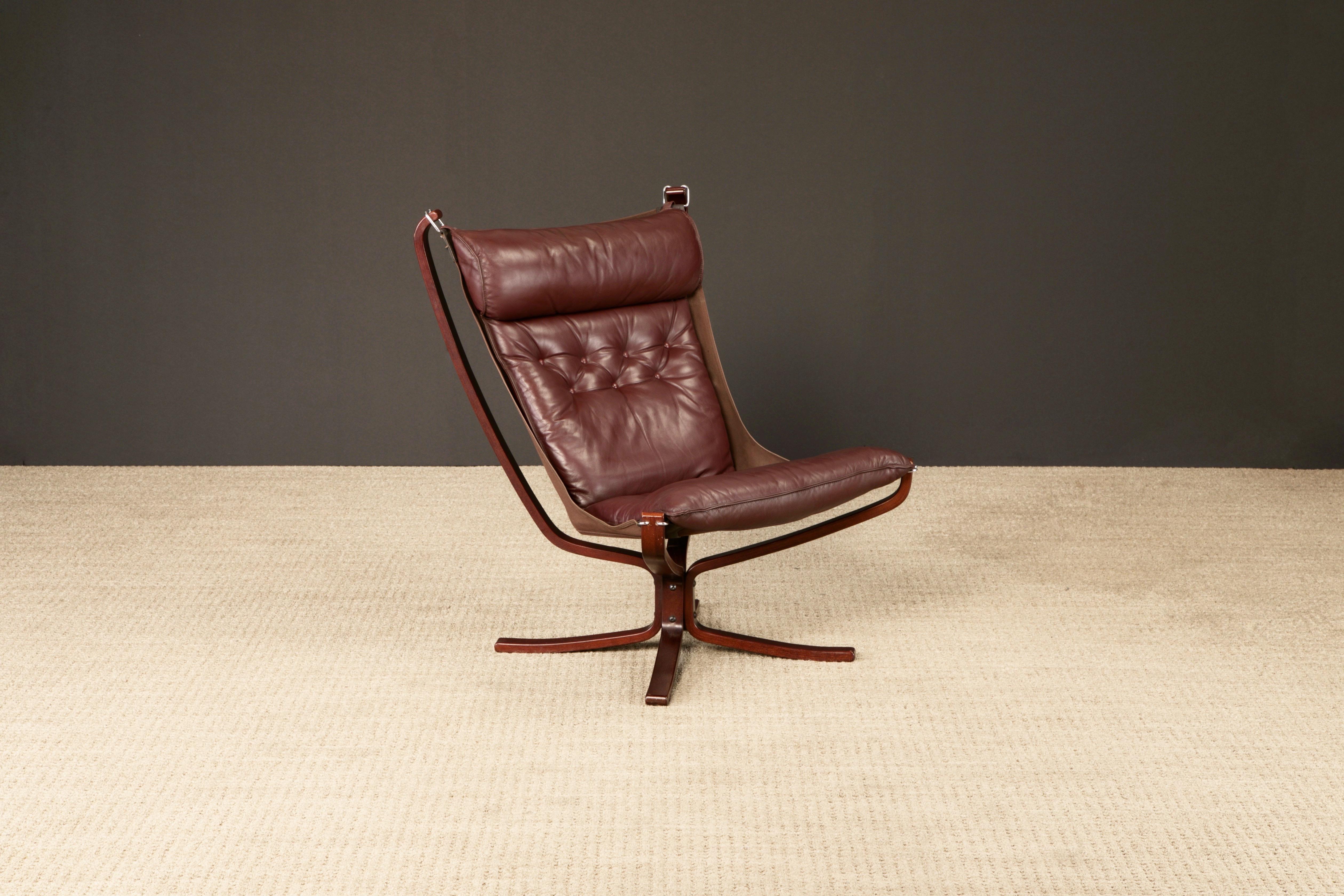 An iconic leather 'Falcon' sling chair in burgundy leather by Sigurd Ressell for Vatne Møbler, suspended in air and harnessed by four sculptural dark wood frame components featuring comfortable and quality burgundy leather cushions that rest in a