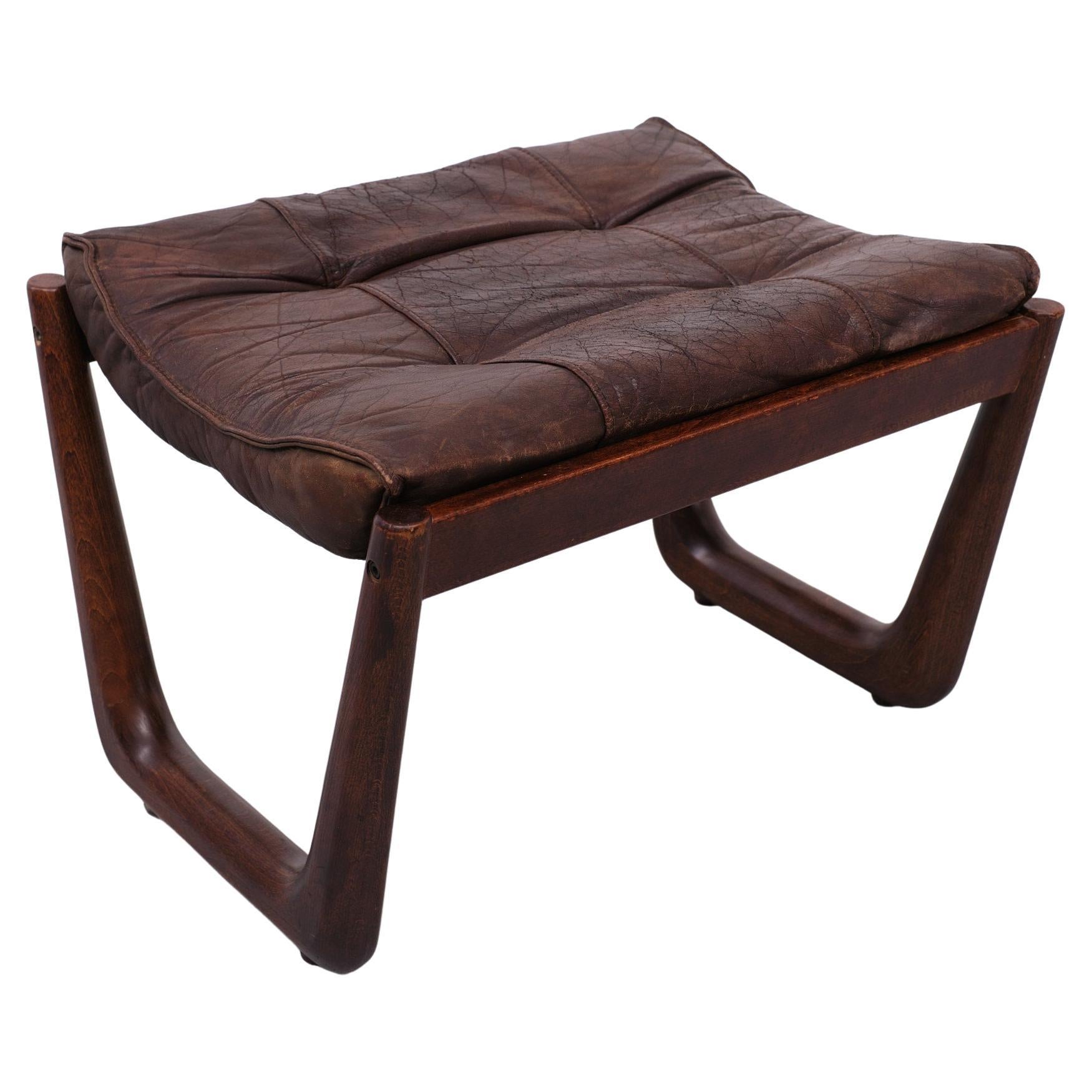 Very nice Foot stool . Well used Leather cushion .Solid Teak wood frame . Manufactured  and signed by  VAD Trevarefabrikk in the 1960s Norway . 
