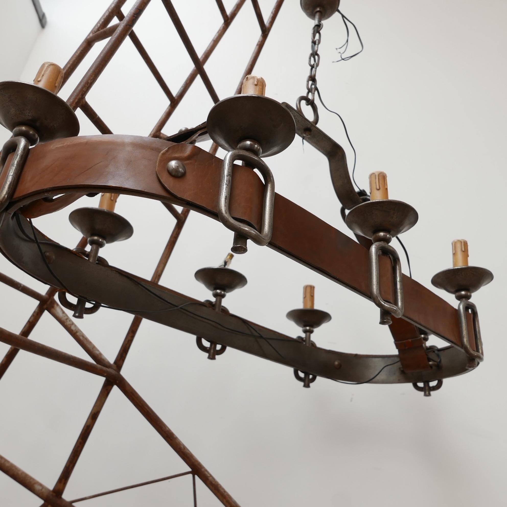 A very good quality French chandelier in the manner of Jacques Adnet. 

France, c1950s. 

Leather work and iron buckles. 

Since re-wired and PAT tested. 

The faux candleholders will be updated to something new as some were lacking.