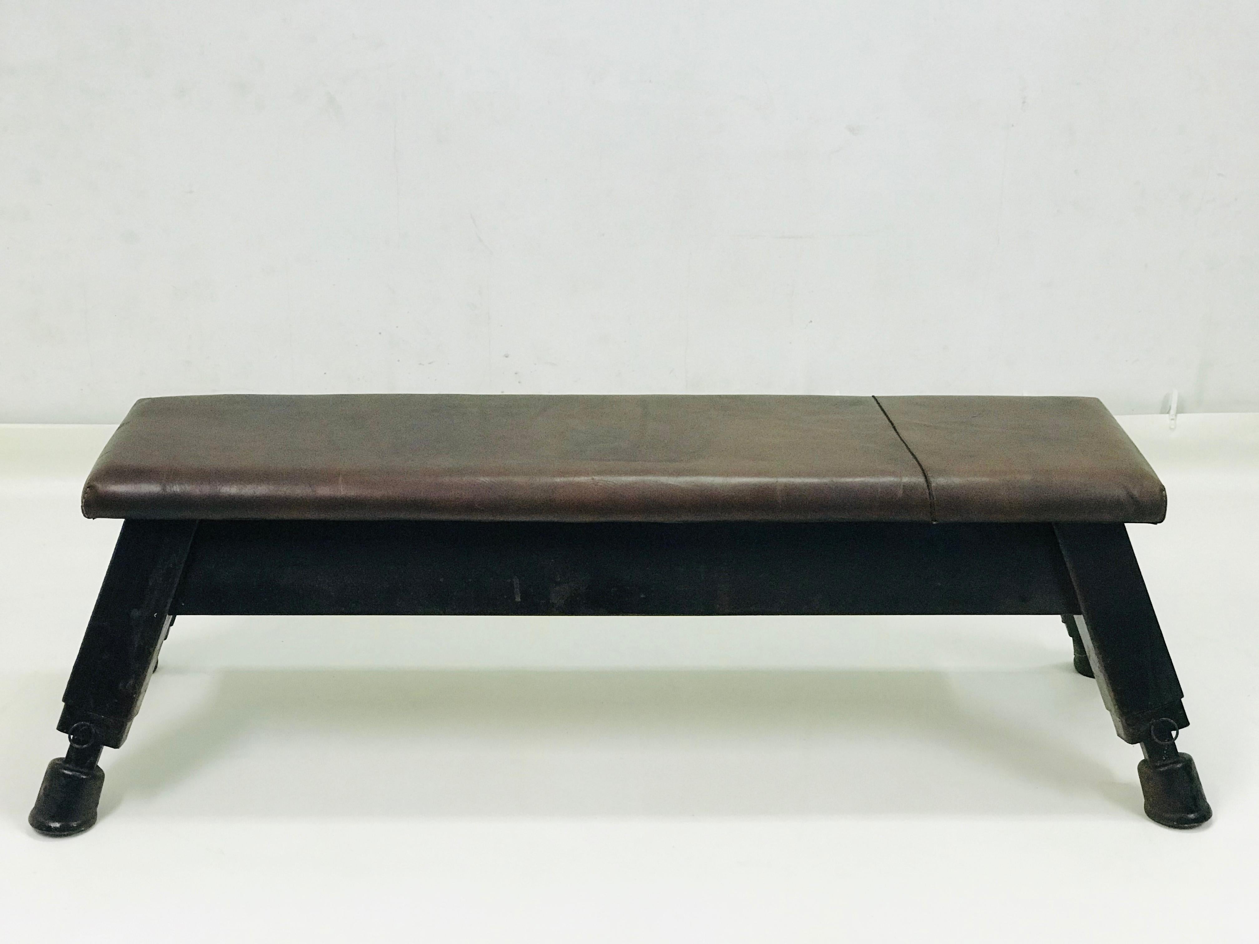 This bench has the massive stable construction with strong leather with original patina. It has setting legs for different height. The dimension of the upper leather desk is 152 x 40 x 7 cm.