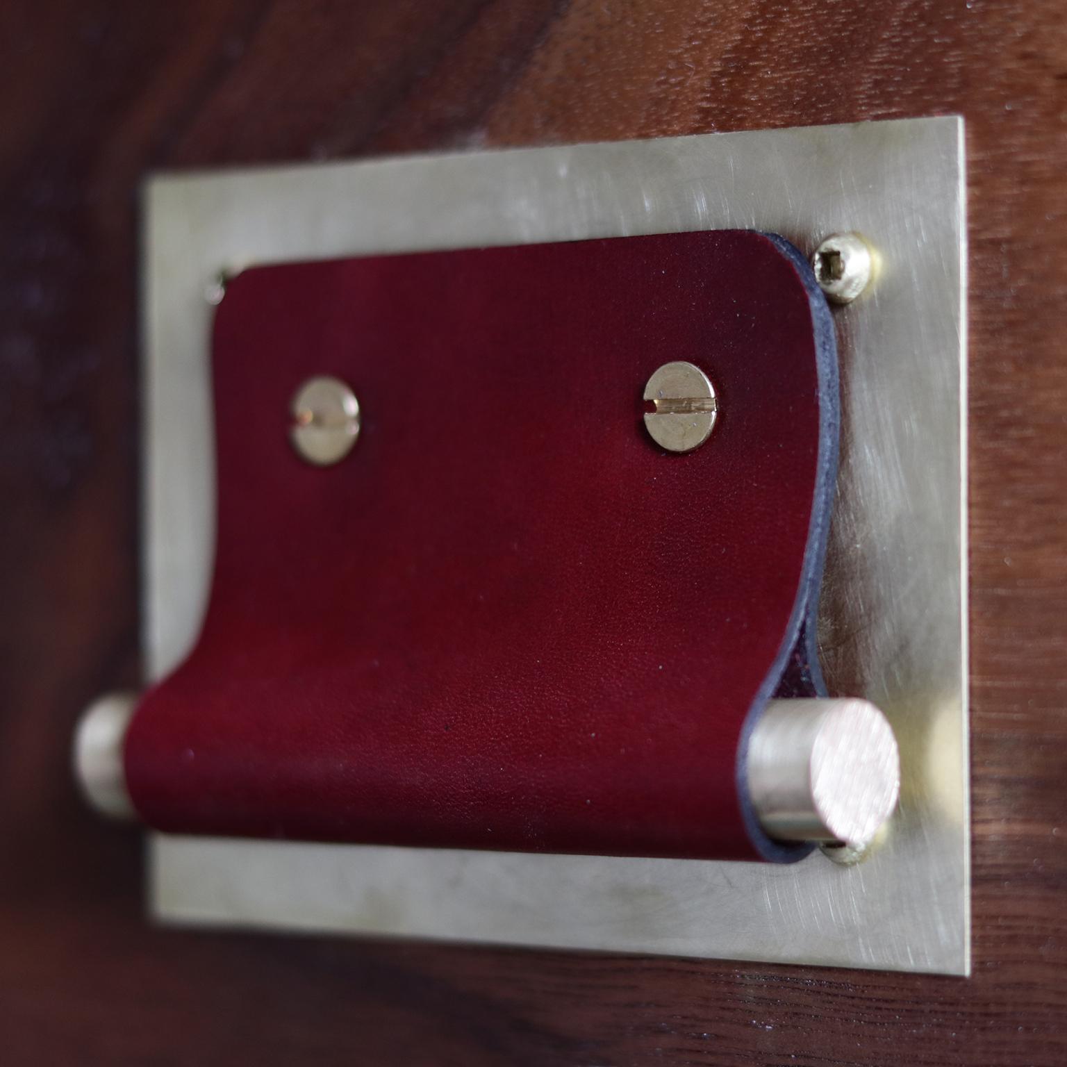 Our leather and brass cabinet door pulls are entirely crafted by hand. Measuring four inches by three inches, the twenty gauge brass plate is burnished by hand and sealed. The leather pulls are individually cut by hand with sealed edges, wrapped