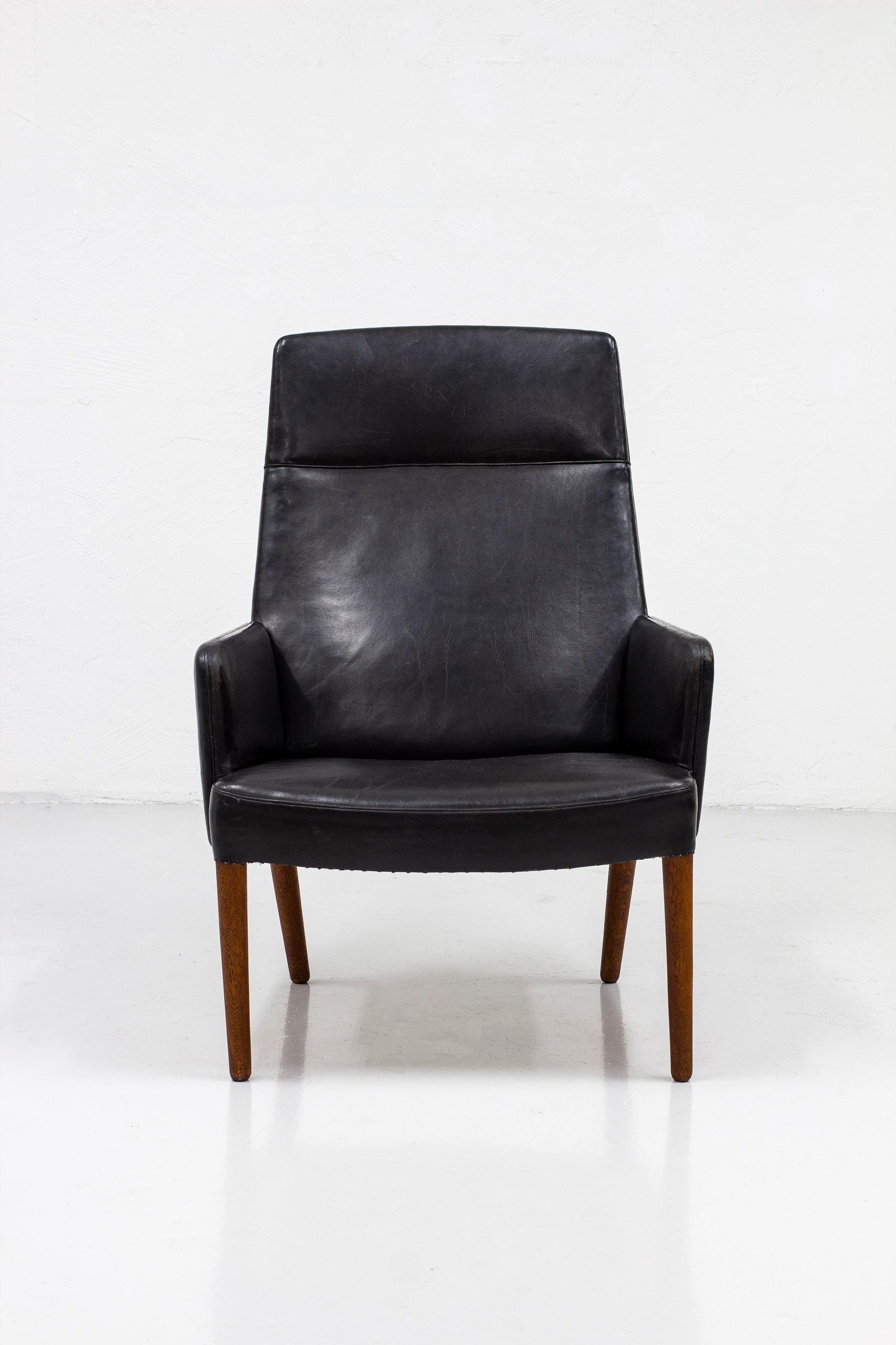 High back lounge chair designed by Danish designer duo Ejnar Larsen & Aksel Bender Madsen. Produced by Aarhus furniture factory in Denmark during the 1950s. Exquisitely hand made original leather work in a beautifully patinated black leather. This