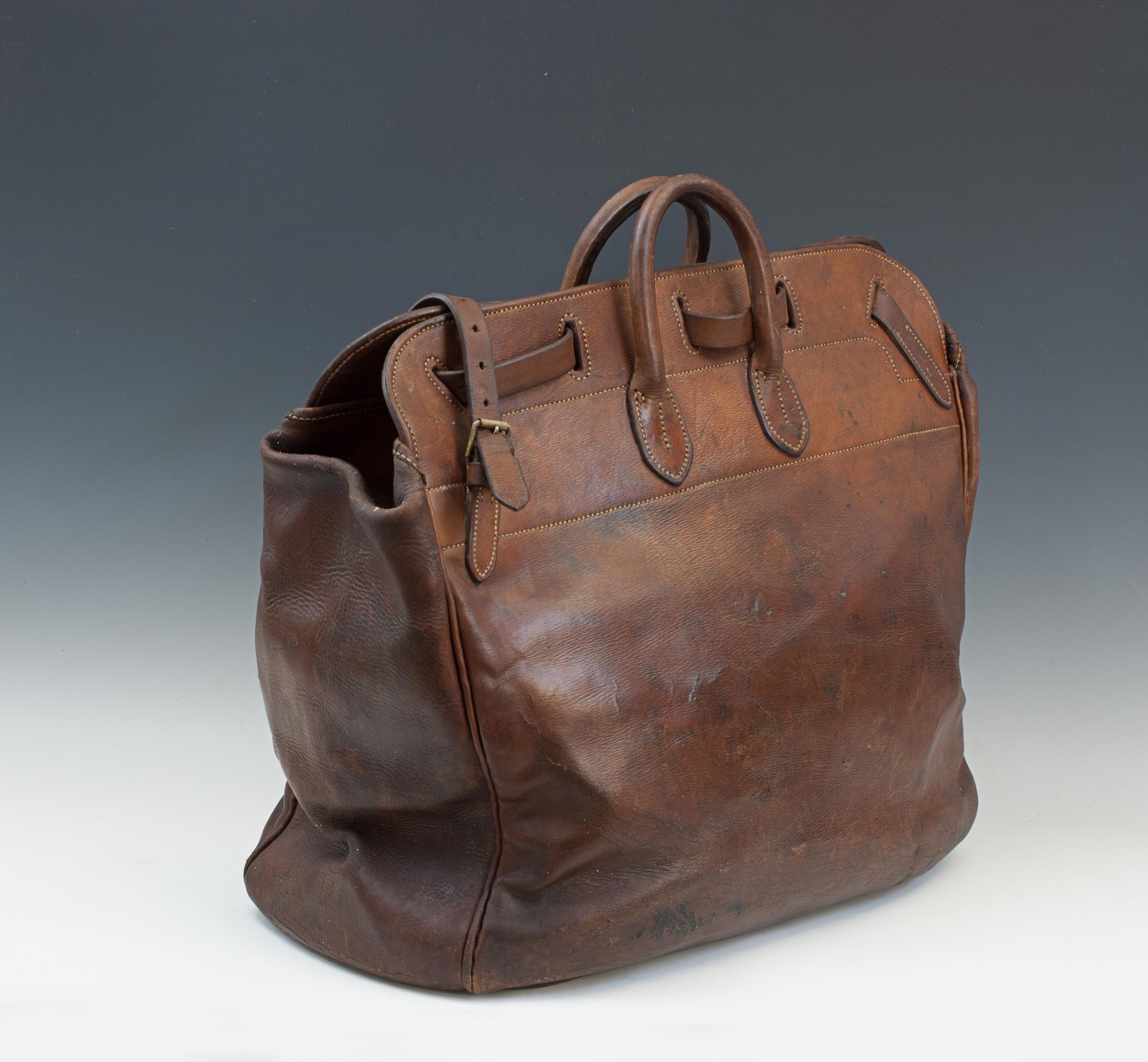 Antike Leder Reisetasche.
Eine gute Reisetasche aus Leder mit zwei starken Tragegriffen und einer sehr ungewöhnlichen Art, die Tasche zu schließen. Der Sicherungsmechanismus erinnert stark an einen Postsack mit einem langen Lederriemen, der durch