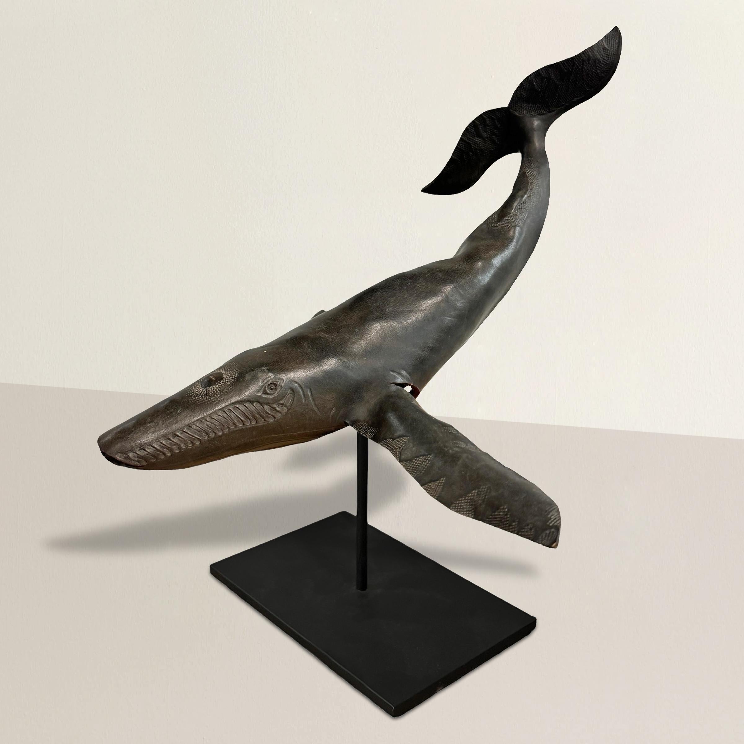 This mid-20th-century American hand-crafted leather humpback whale, found in one of Oregon's picturesque coastal towns, is a stunning example of traditional craftsmanship and creativity. Expertly molded by hand, the dimensional body of the whale