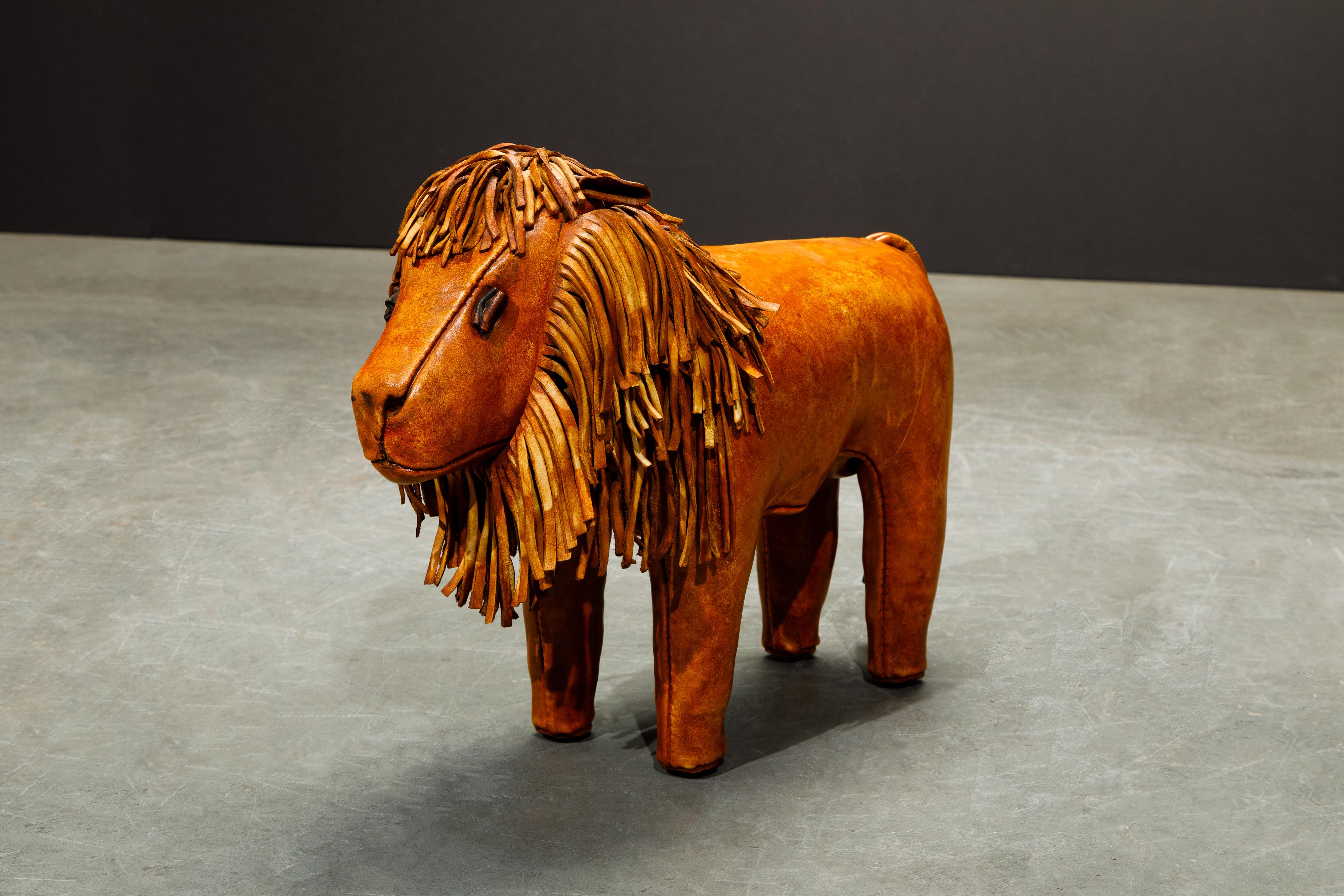 A wonderful collectors example of an original leather lion footstool by Dimitri Omersa for Abercrombie and Fitch, circa 1960s. This example has the early nailheads under its feet, and is in beautifully aged and lightly patinated gorgeous golden