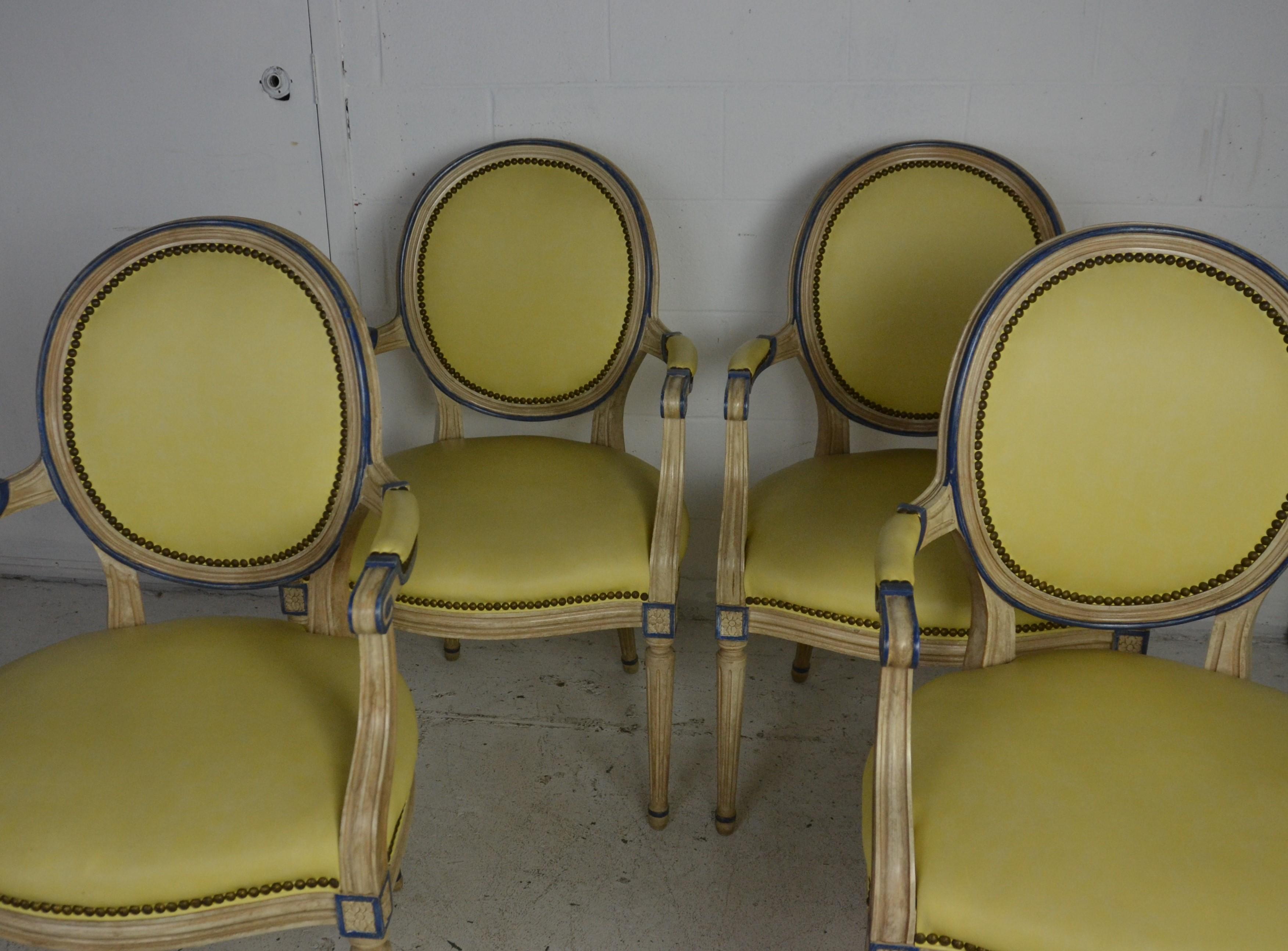 A set of 4 armchairs / dining chairs in the Louis XVI style. Upholstered in light yellow leather. Measure: Arm 26.25