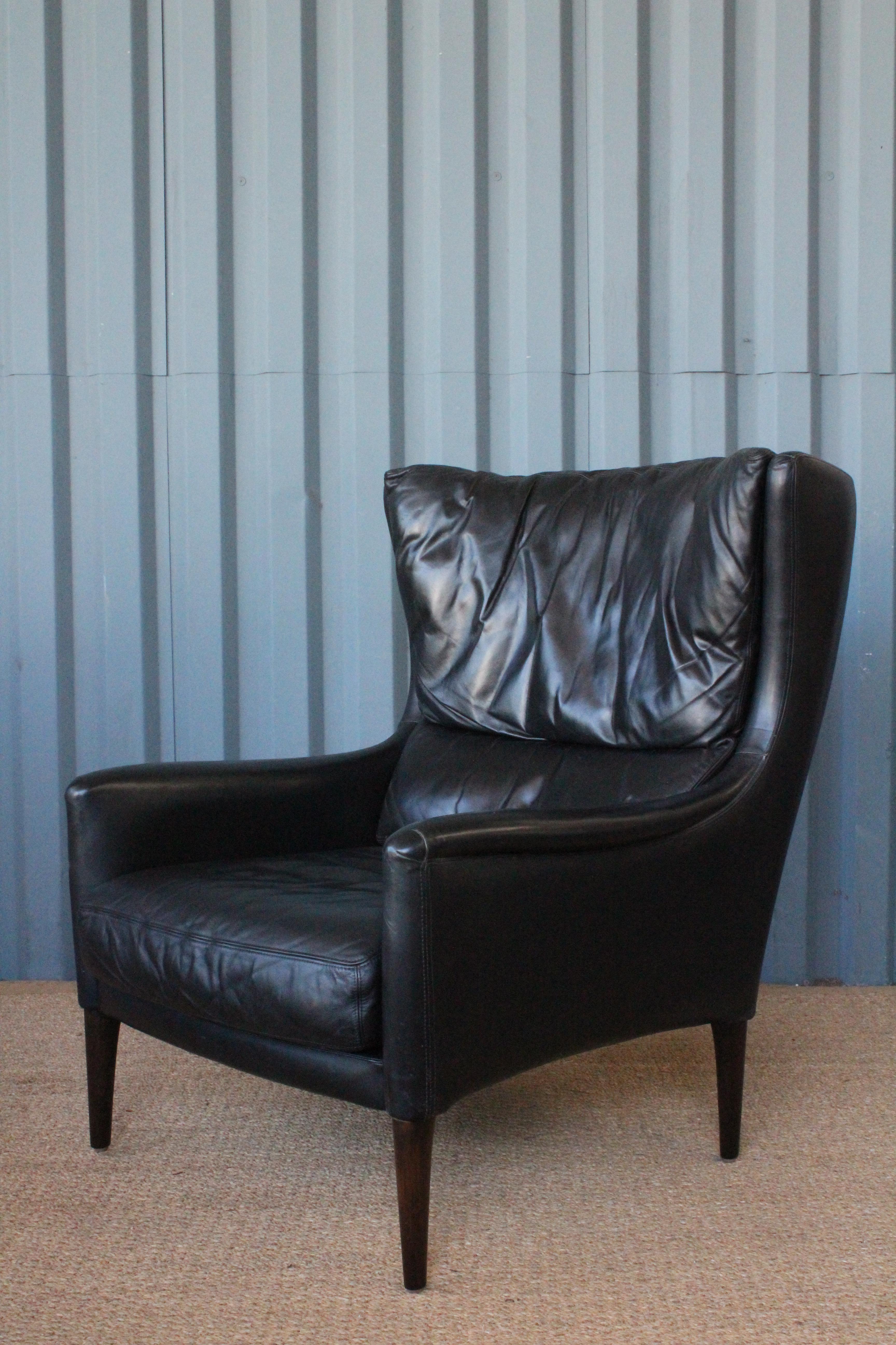 Leather lounge chair by Kurt Østervig, Denmark, 1950s. Original black leather is in fantastic condition. The legs have been replaced and copied as the originals in a stained oak. Overall wonderful condition with some age appropriate wear to the