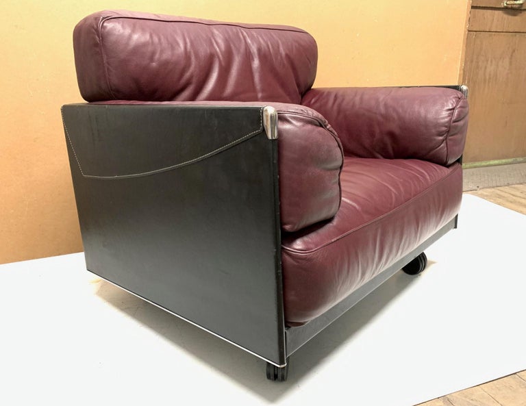 Italian leather lounge by Poltrona Frau. Has stitched leather, chrome by the arm tips with steel to the bottom back and sides. The chair has wheels only to the front. Chair retains label.
     