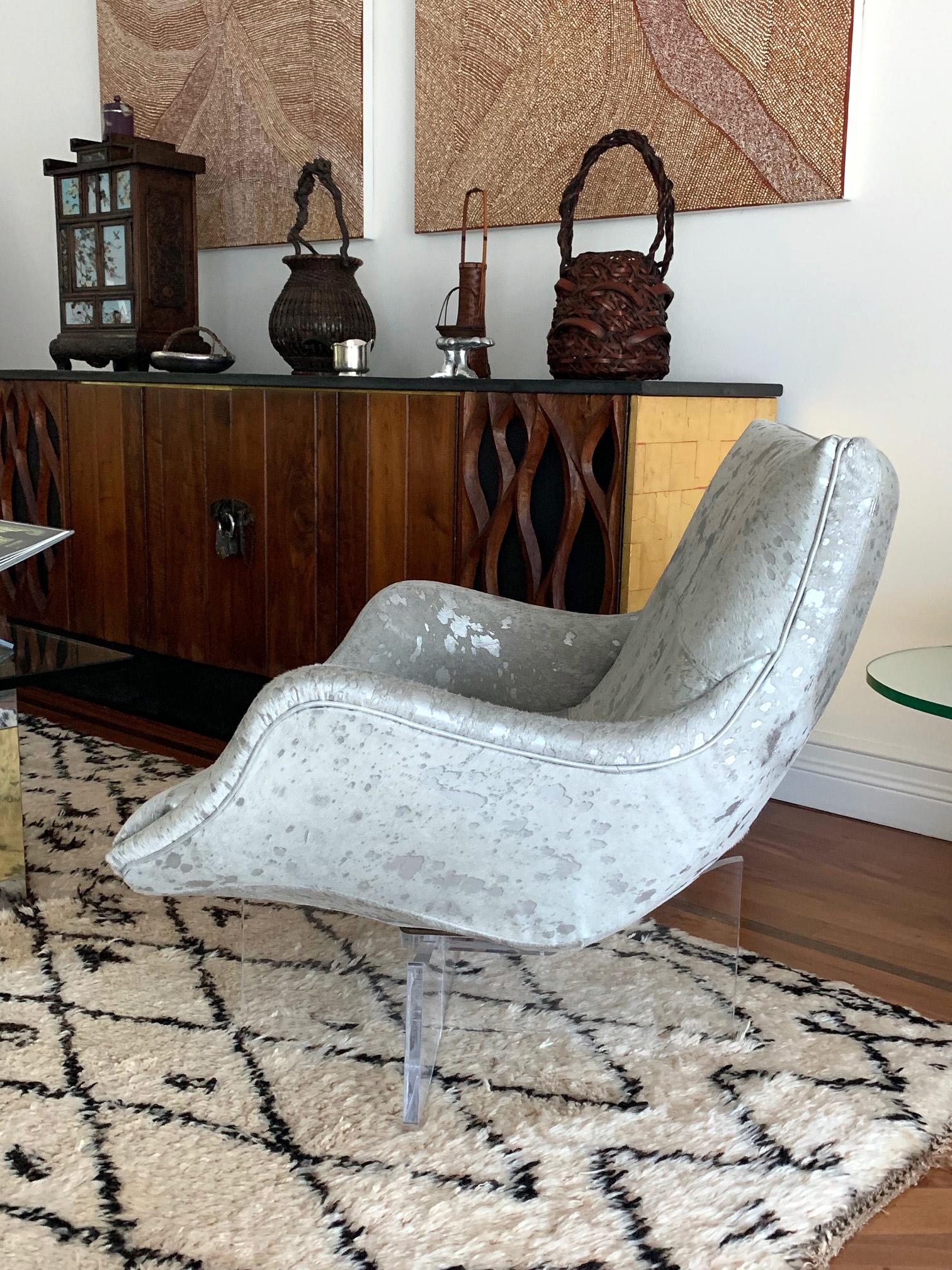 One of the iconic designs by Vladimir Kagan circa 1970s, this chaise lounge or club chair rests on a cross bracket Lucite base and seduces you for a rest. The well contoured form hugs the body while the Lucite base gives a sense of floating from the