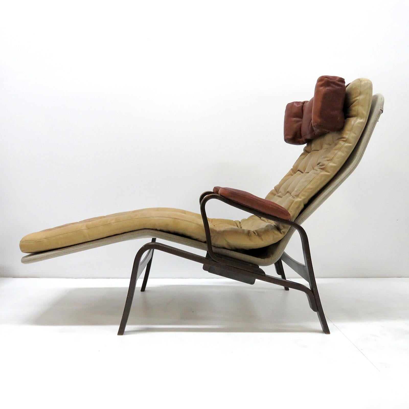 Wonderful reclining lounge chair/chaise by Sam Larsson for DUX, 1970, in camel colored leather on a canvas covered metal frame. Headrest and arm cushions in cognac colored leather on a dark-stained bentwood frame, marked with DUX print on the back
