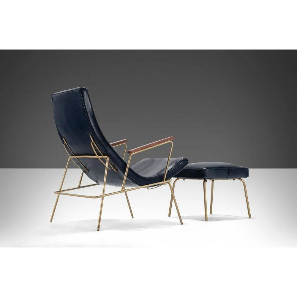 Recently upholstered in dark navy blue full grain leather resting on a gold powder coated steel base and accented by minimal walnut arm rests. The chair can sit up right or recline on it's original slide reclining mechanism. The chair is stately and