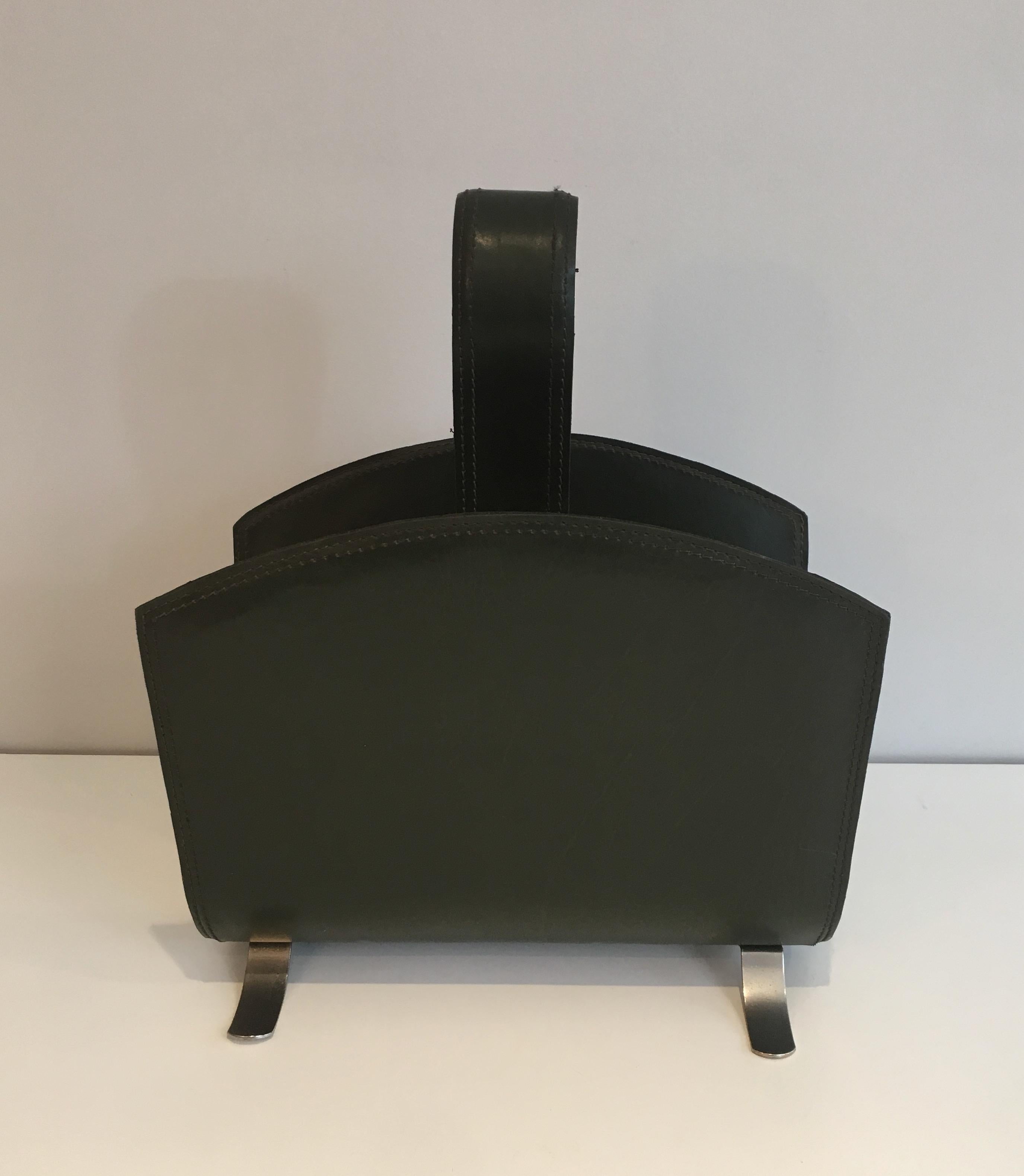 This magazine rack is made of black leather on a brushed steel base. This is a French work, in the style of famous designer Jacques Adnet, circa 1950.