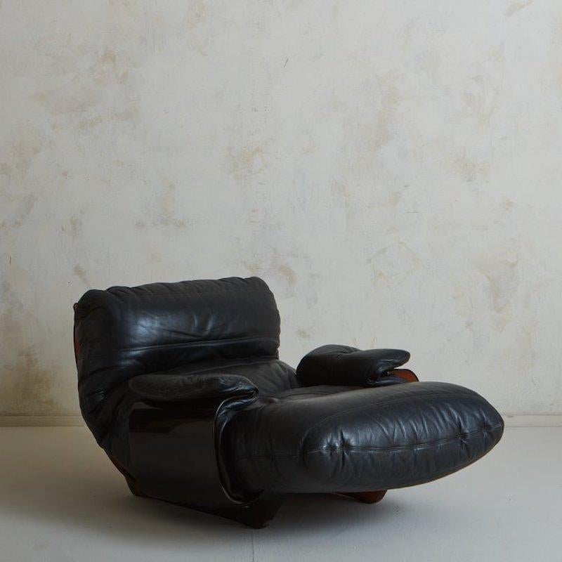 Der von Michel Ducaroy für Lignet Roset entworfene Stuhl Marsala hat einen skulpturalen Rahmen aus bernsteinfarbenem Plexiglas, der vollständig gebogen ist. Dieser Marsala-Stuhl ist mit schwarzem Leder gepolstert und mit wunderschönen Nähten