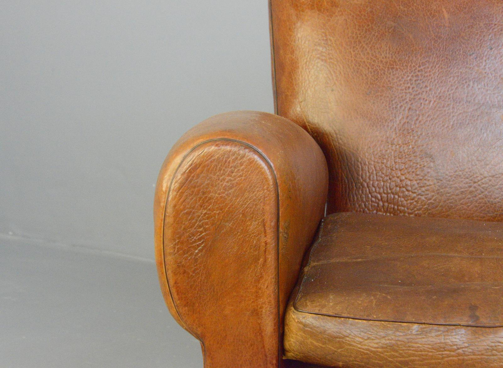 Leather moustache back armchair, circa 1930s

- Cognac textured leather
- Brass studs on the back
- Sprung seats, backrests and arms
- Moustache detail to the headrest
- French, 1930s
- Measures: 89cm wide x 86cm deep x 84cm tall
- 42cm seat