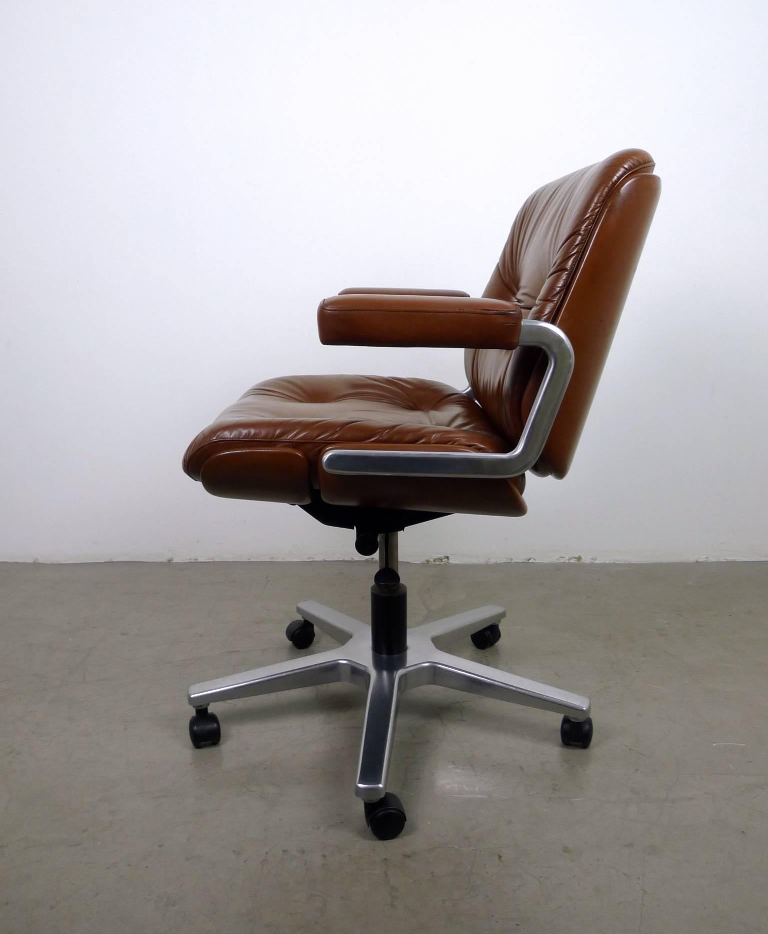 Elaborate and very comfortable office chair with maroon colored leather from the Swiss manufacturer Stoll Giroflex AG.
The chair is wheel able, revolving and adjustable in height and grade. The pressure spring is fully functional and the seating