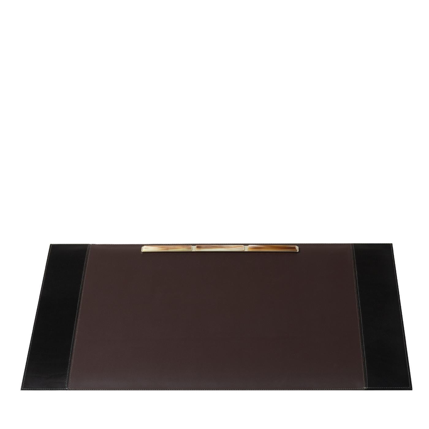 Sophisticated and timeless, this elegant leather pad combines precious materials and traditional craftsmanship, adding a stunning accent to a study or office desk. Its simple brown leather surface is adorned with a piece of natural horn at the top