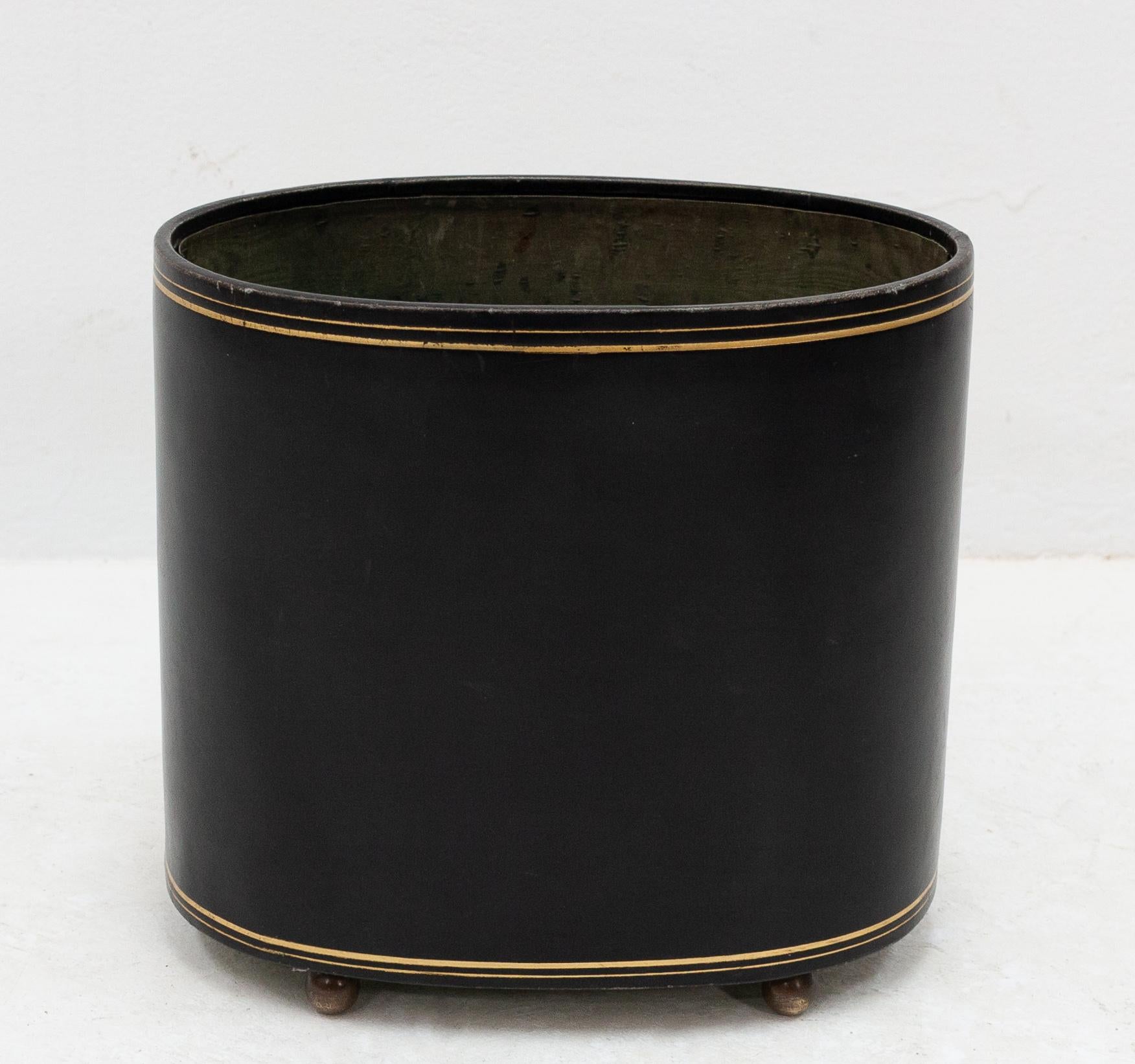 Beautiful leather paper basket. Oval in shape with a golden striping. Standing on solid brass
feet. This paper basket still has its original green silk lining. Made in Spain.