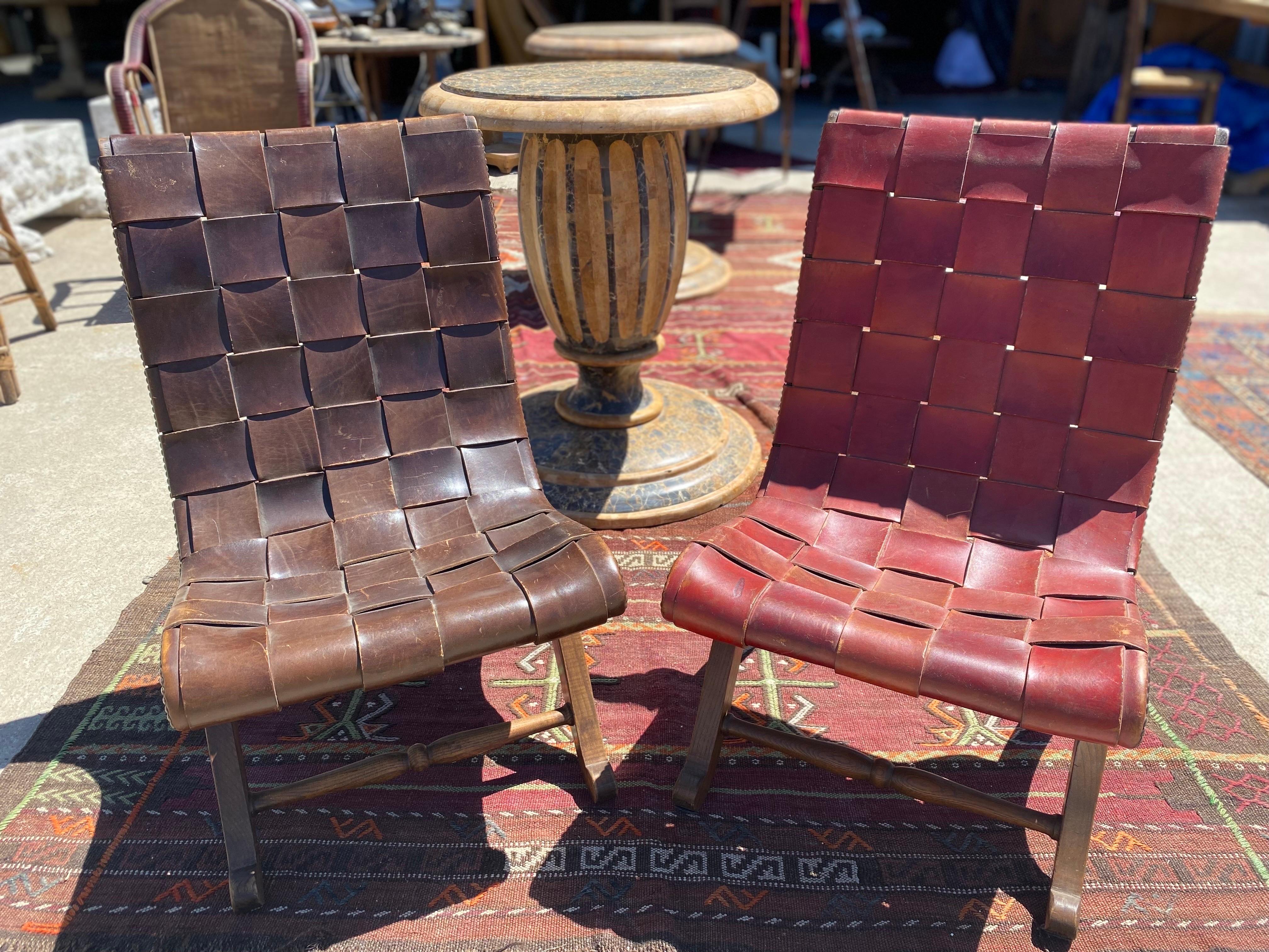 Pair of mid-century, neoclassical thick leather PIerre Lottier slipper chairs, circa 1950s, Spain. One chair features a rich brown color and the other is a burgundy color, both have beautiful naturally aged patina. Upholstered in their original