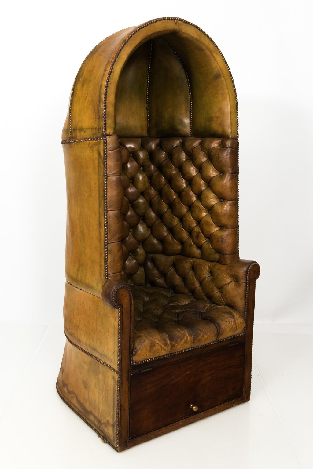 English tufted leather porter's chair with brass nailhead trim and bottom hatch, circa 19th century. Please note that the leather has minor wear throughout with water damage and the spring seat base needs refinishing.
 