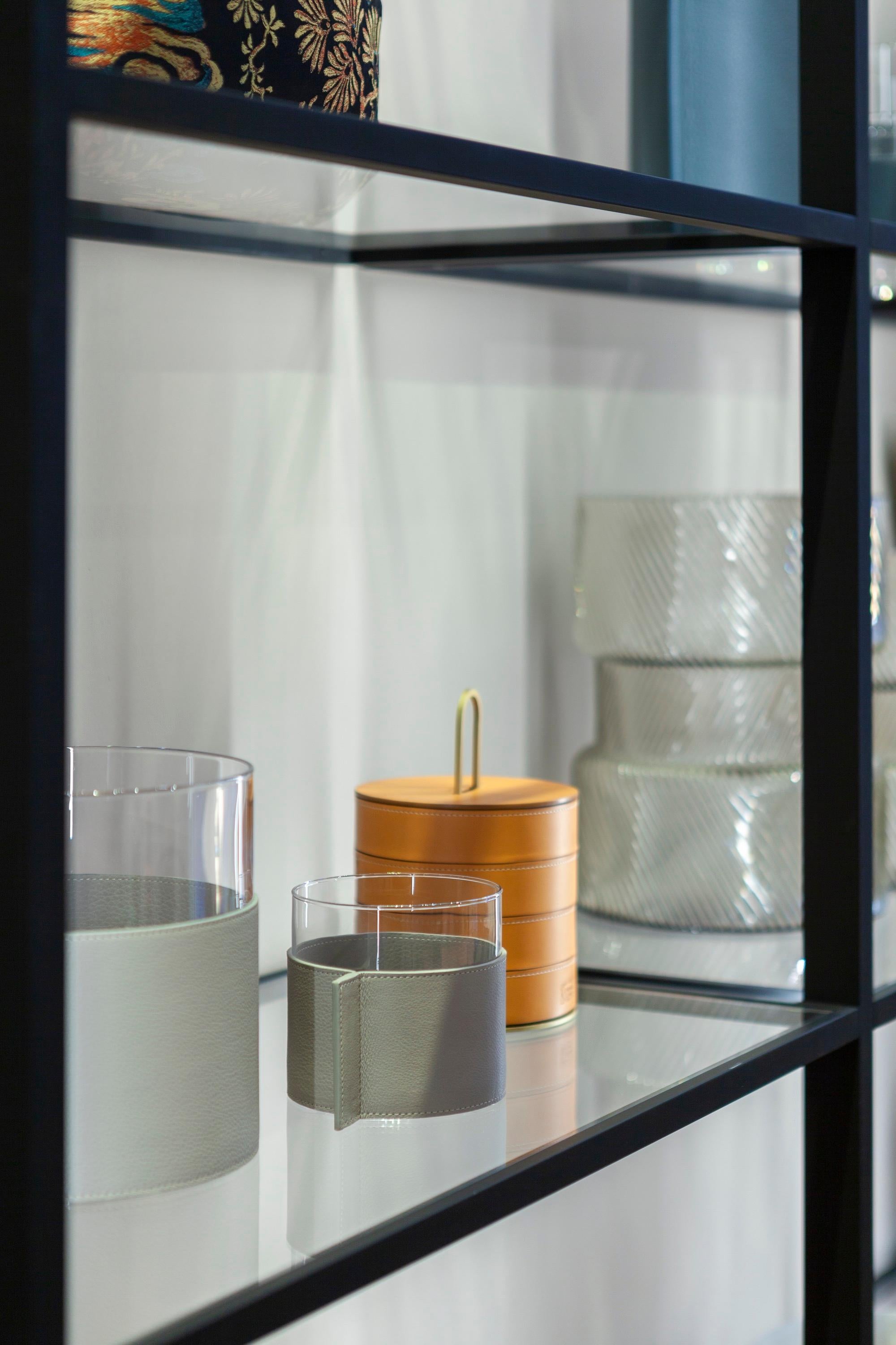 Leather pot is a transparent glass and soft leather for a family of open vases that can be mixed and matched or used on their own. The Leather Pot vases collection, designed by Poltrona Frau, consists of three simple transparent glass cylinders in